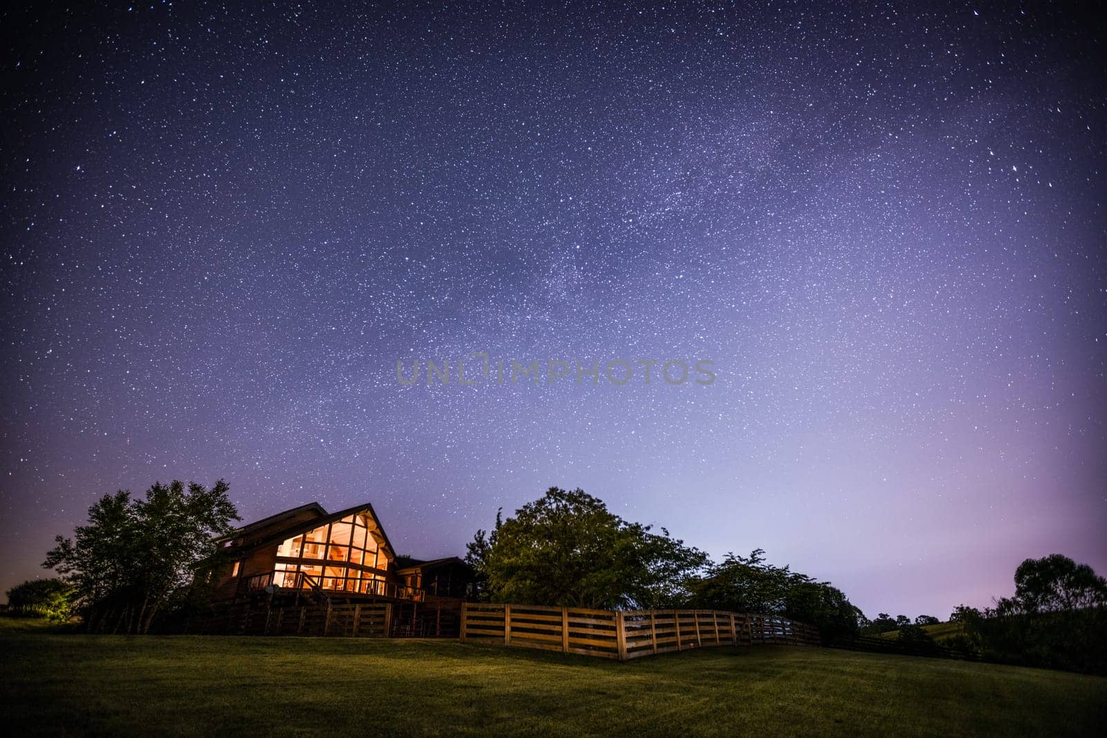 View of night sky and the Milky Way with a house in rural Kentucky in the foreground