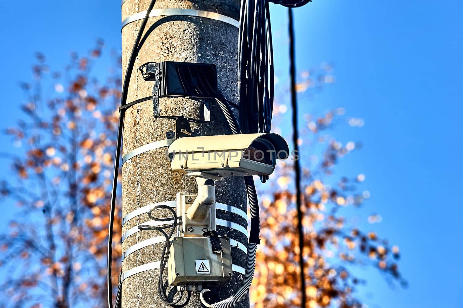 a surveillance camera is hanging on a concrete pillar with an infrared flashlight. High quality photo