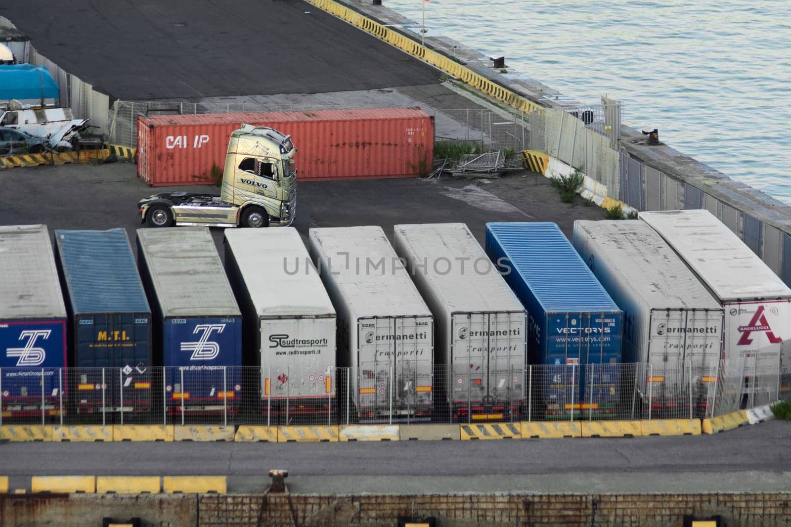 Civitavecchia, Italy - February 7, 2025: Truck at cargo terminal surrounded by cargo containers, representing international freight transport. Concept: Freight transportation and commercial trucks