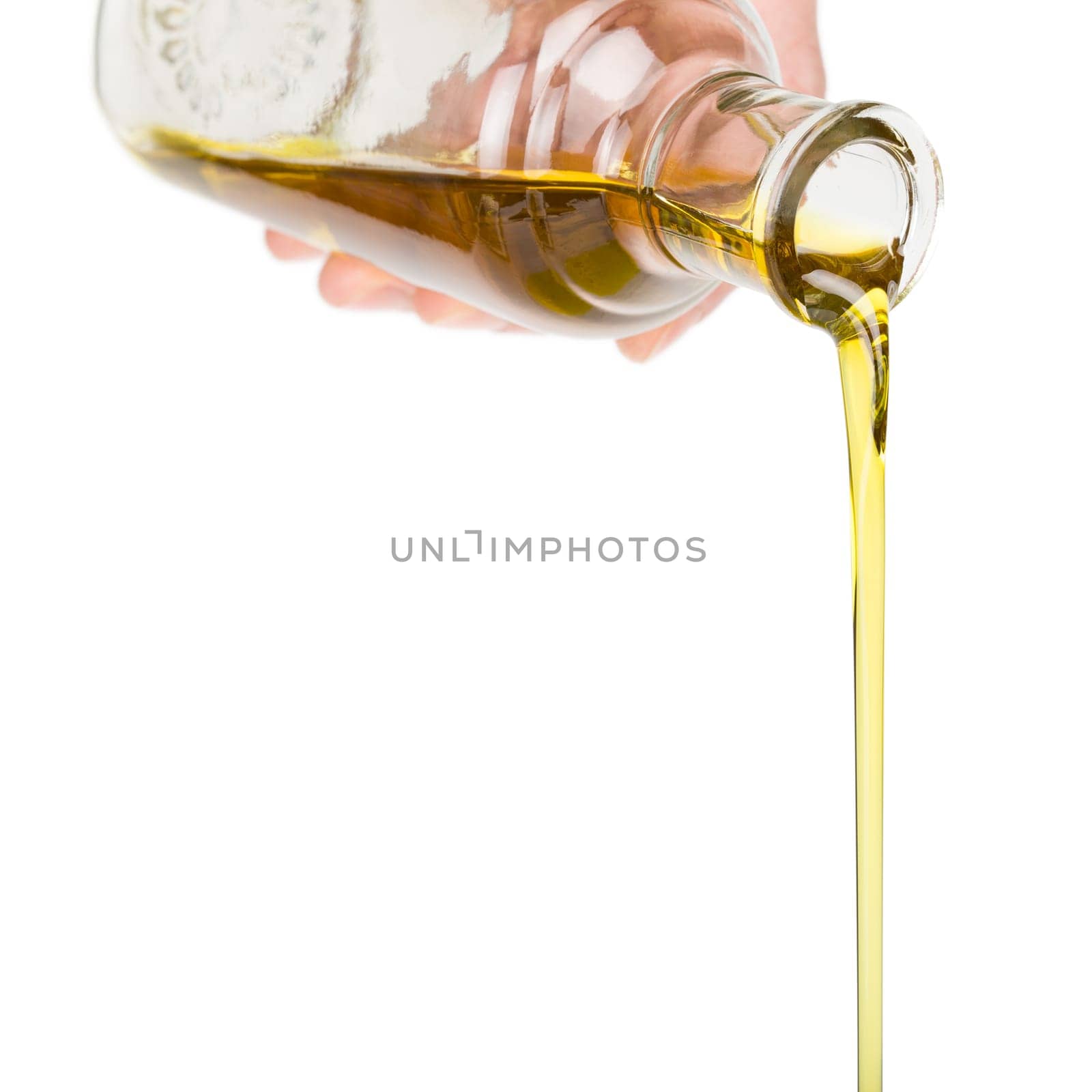 Male hand holding a bottle. Oil pouring from a bottle.