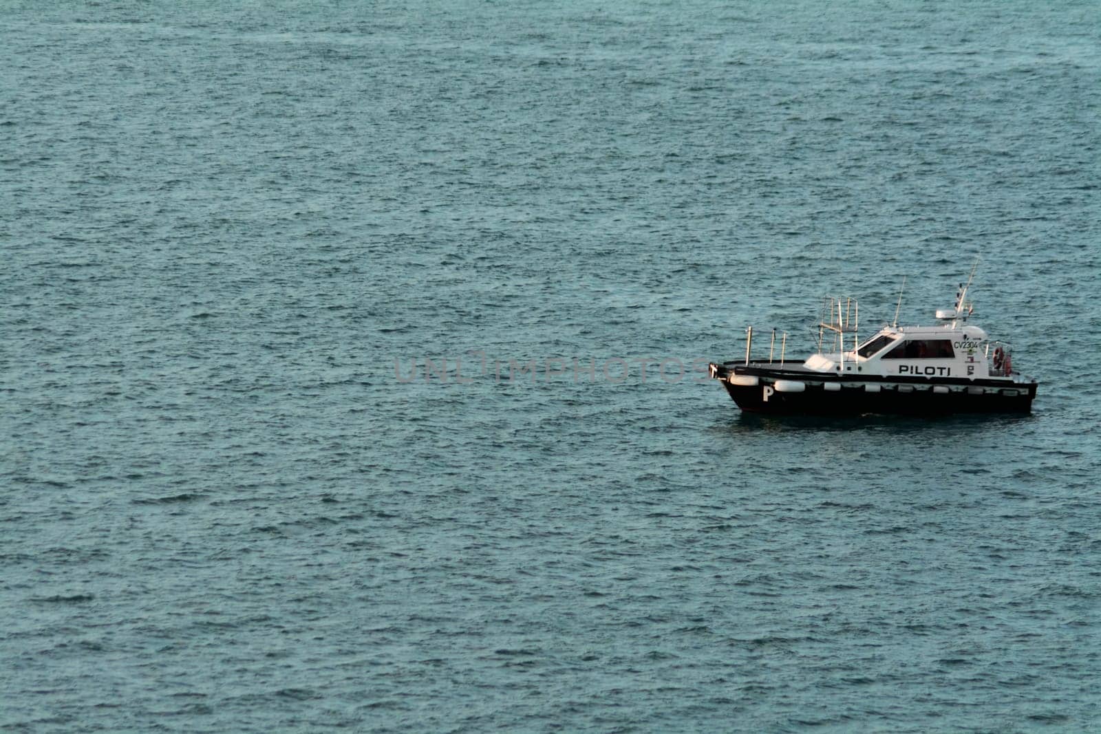 Civitavecchia. Italy - February 07, 2025: A pilot boat floats on the high seas, essential for maritime logistics and port operations. Concept: Nautical transport and safety
