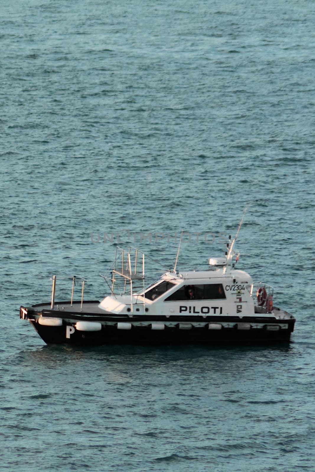 Civitavecchia. Italy - February 7, 2025: Pilot boat in calm waters, used to guide ships into ports. crucial part of maritime trade and navigation. Concept Logistics and port assistance