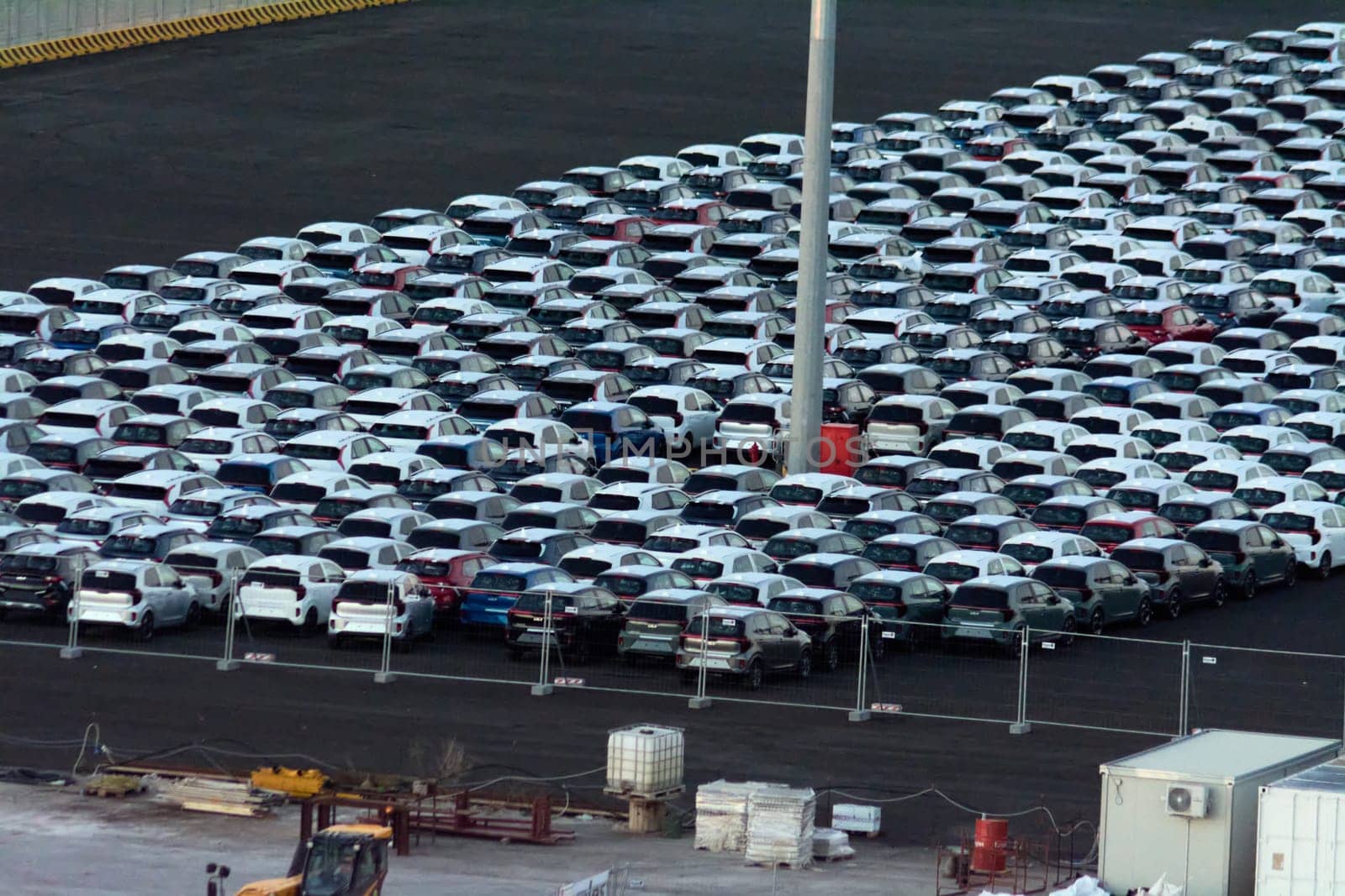Civitavecchia. Italy - February 7, 2025: Aerial view of new vehicles parked in a port, ready for transport. Essential for delivery to the market. Concept: International trade, logistics operations