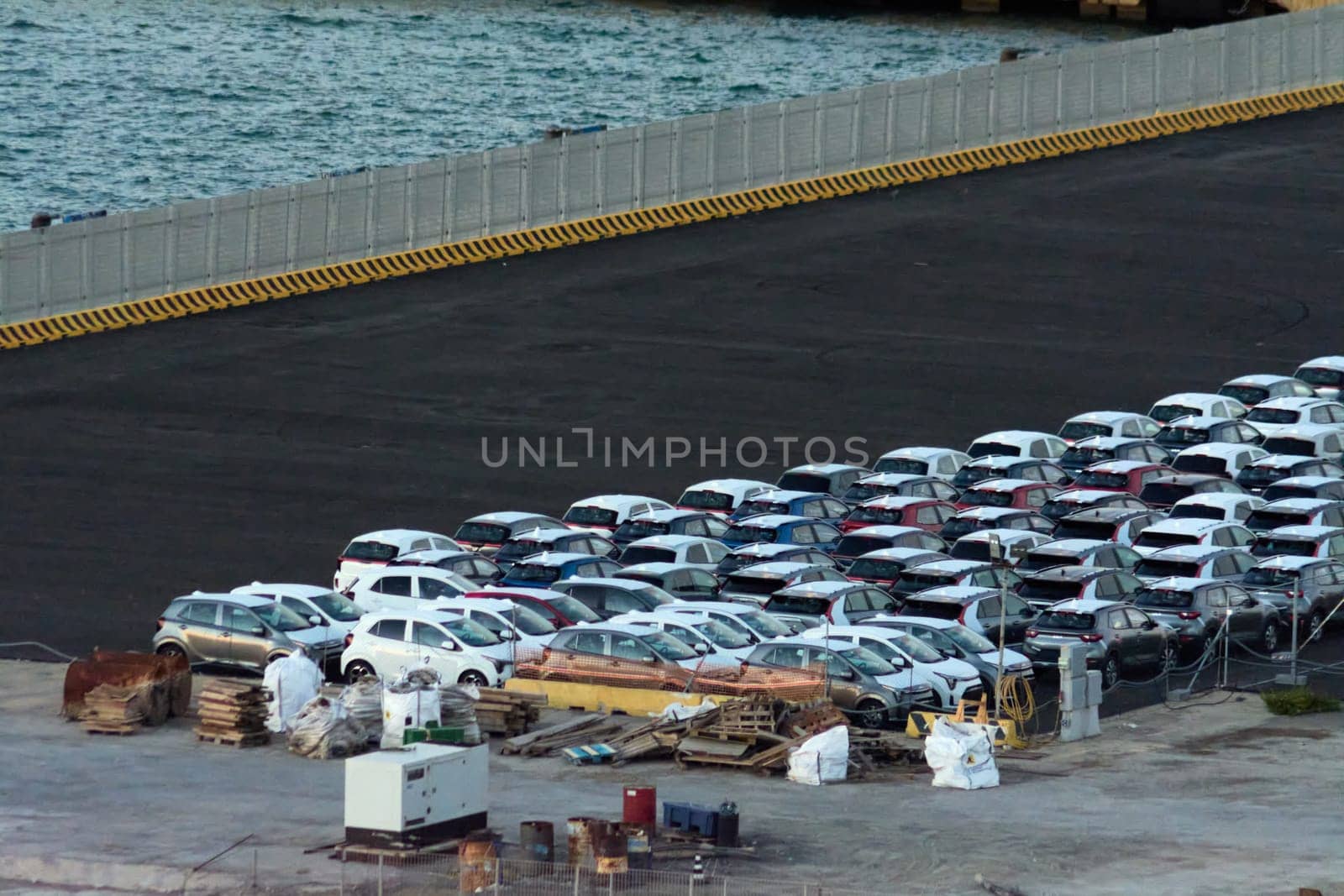 Civitavecchia, Italy - February 7, 2025: Aerial view of manufactured vehicles at a port. Highlights automotive supply chain, export logistics and global transportation Critical for market distribution