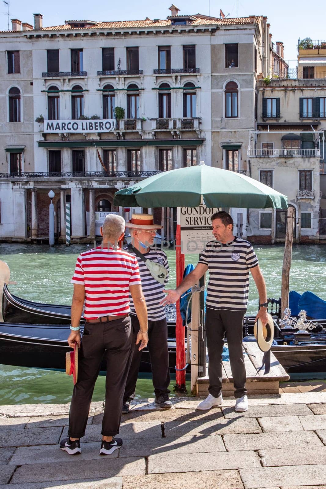 Venice, Italy - July 7, 2021: Gondoliere waiting at the gondola stop for passengers in Venice, Italy.
