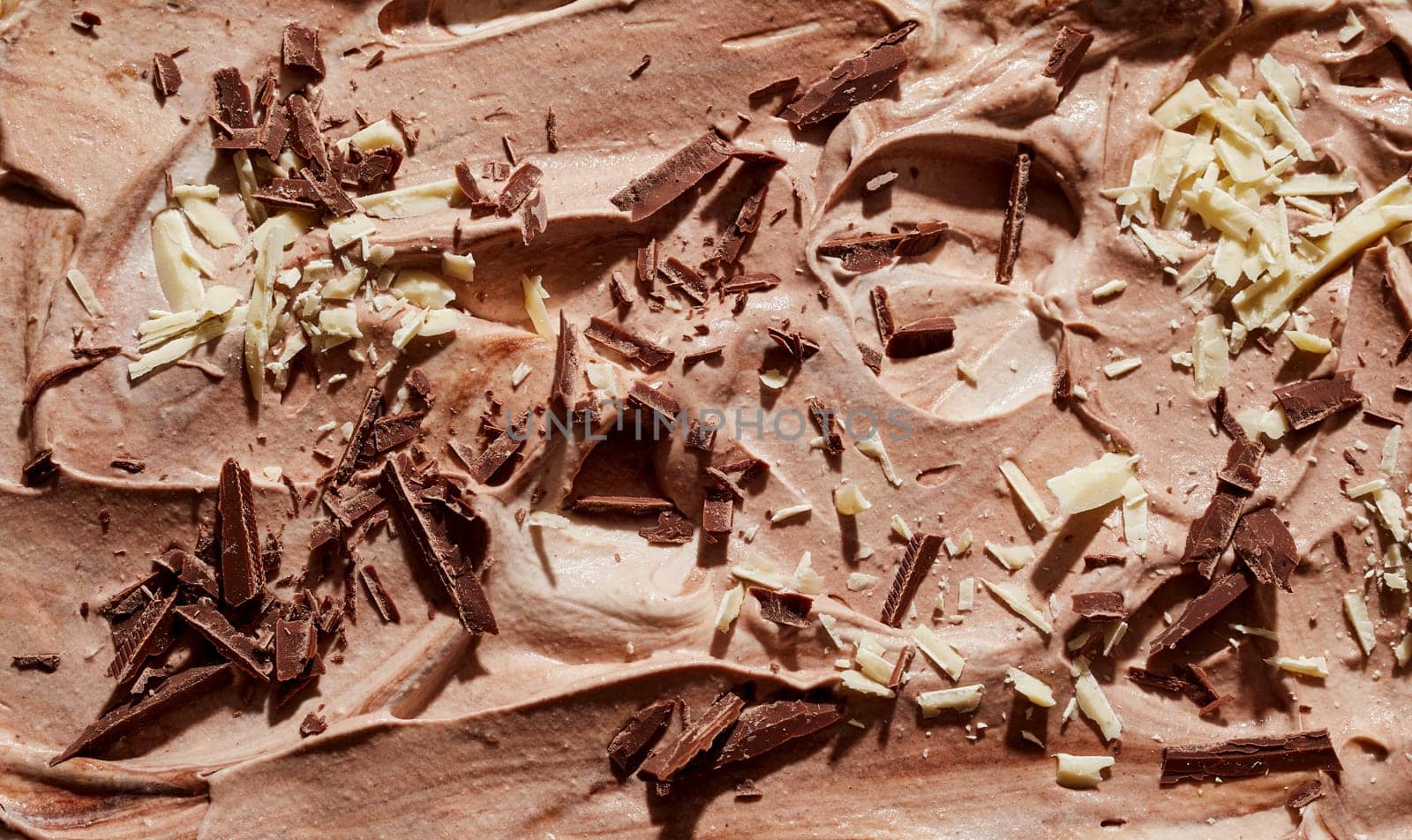 Chocolate ice cream dessert with flaked almonds and chocolate shavings topping in a full frame background texture for menu advertising