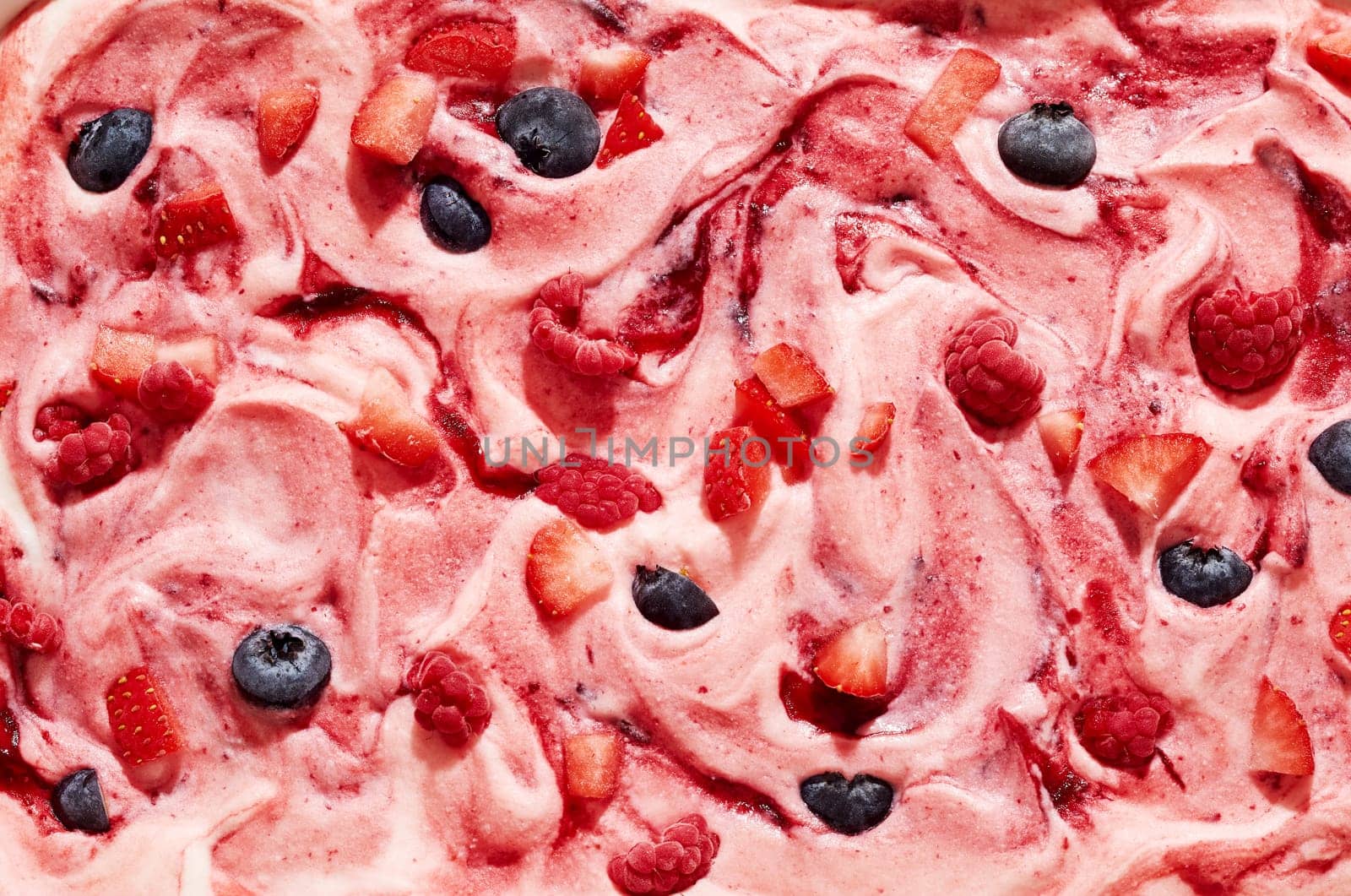 Gourmet speciality creamy mixed berry ice cream with raspberry, strawberry and blueberry fruit chunks in a full frame view for menu or product advertising