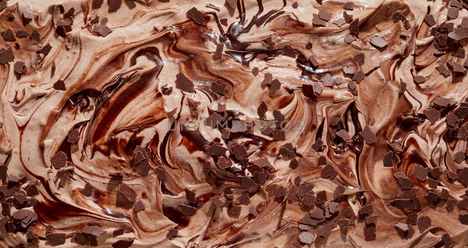 Tasty speciality Italian creamy chocolate ice cream or gelato topped with chocolate flakes in a close up textured background with swirl pattern