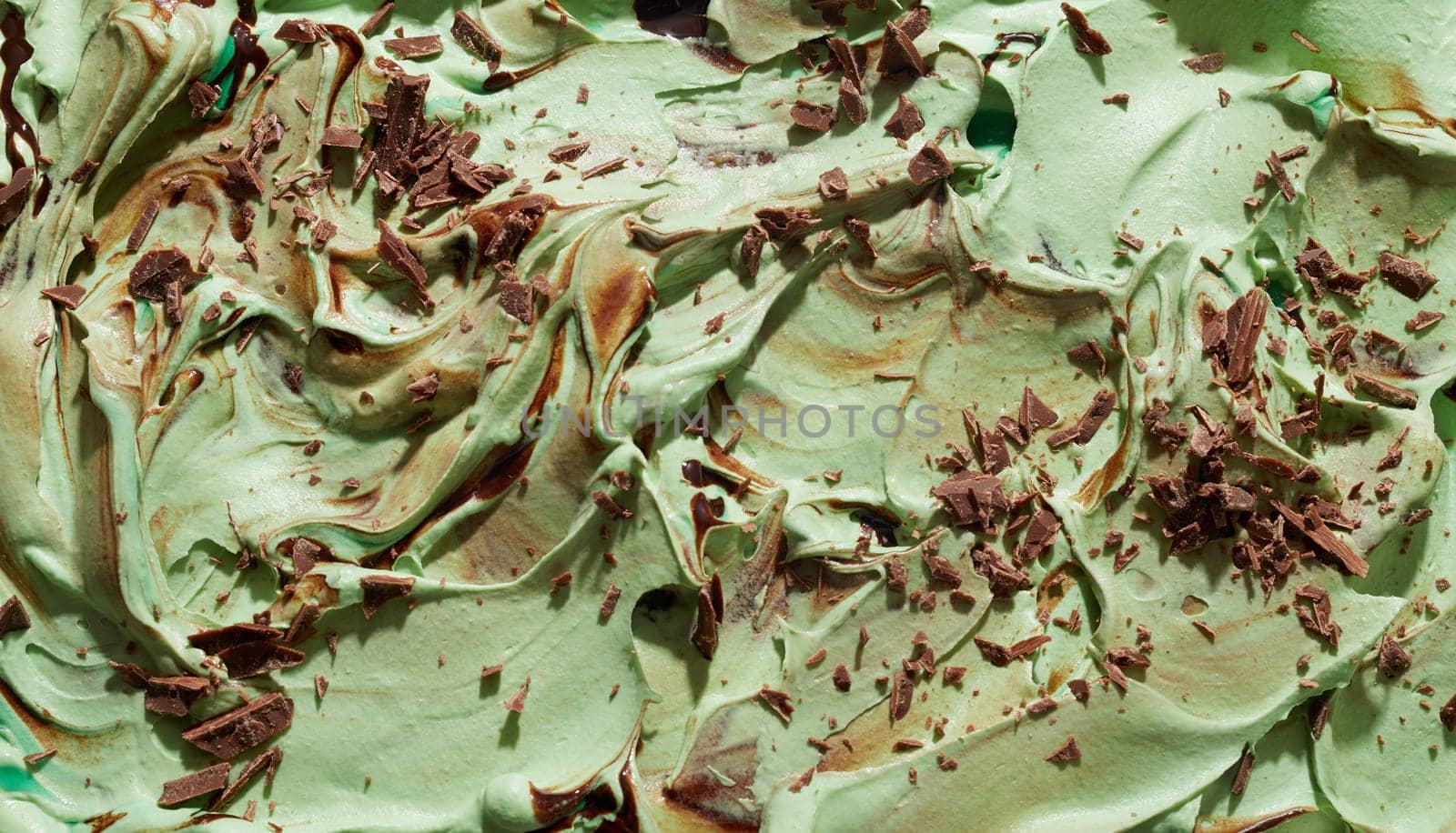 Mint, Japanese green tea or matcha ice cream with chocolate flakes in a textured swirling background texture close up on the surface of the dessert