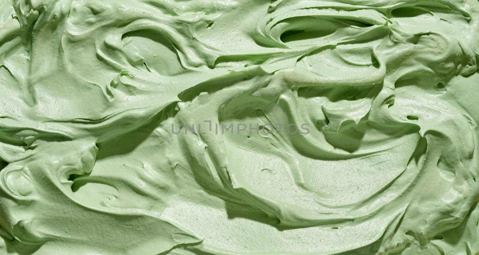 Speciality Japanese green tea or matcha ice cream texture in minty green with a swirling ridged surface in close up full frame for menu or product advertising