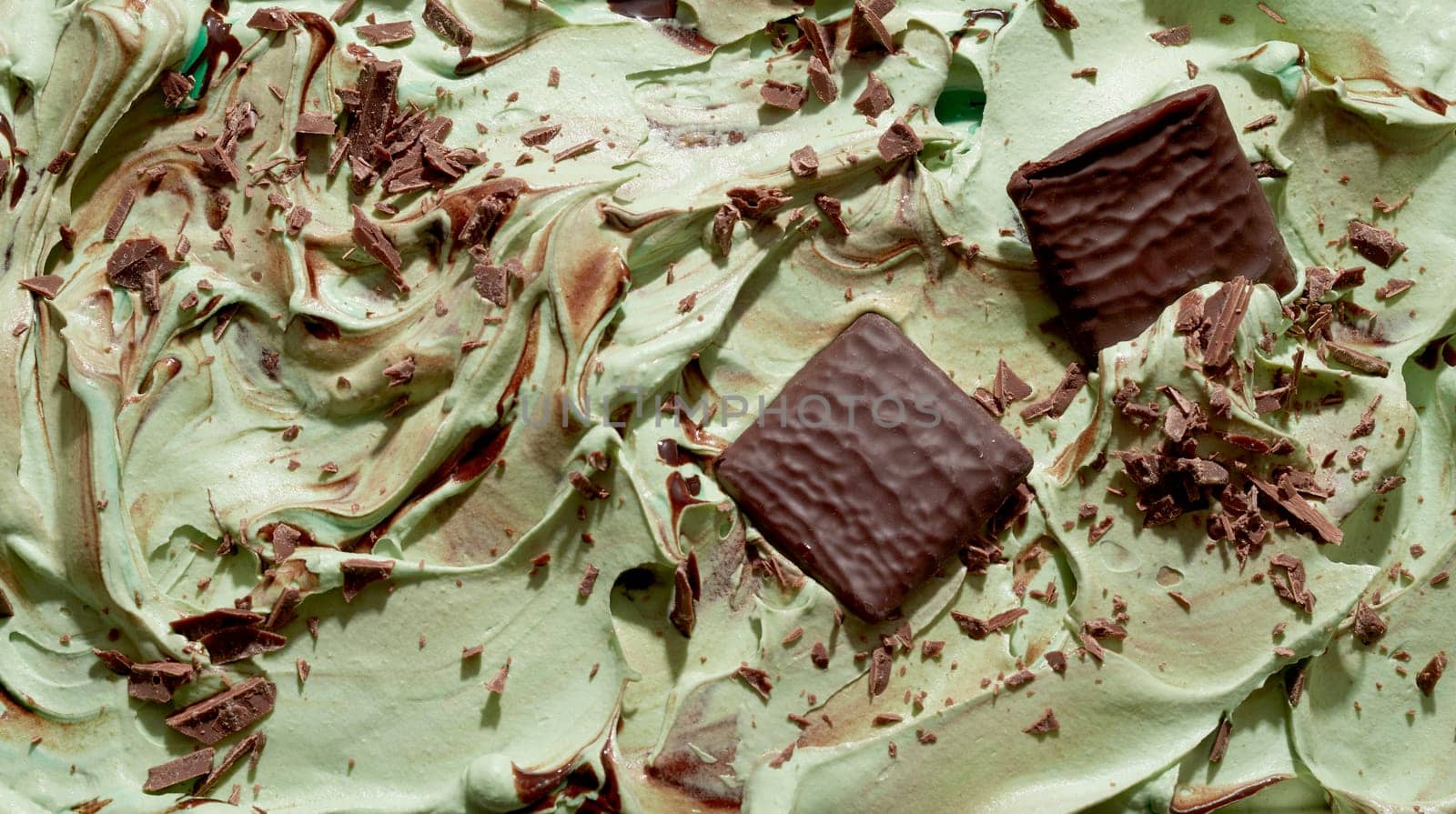 Delicious chocolate chip and mint ice cream full frame texture with chocolate flakes and wafers on the surface of creamy green ice-cream in close up