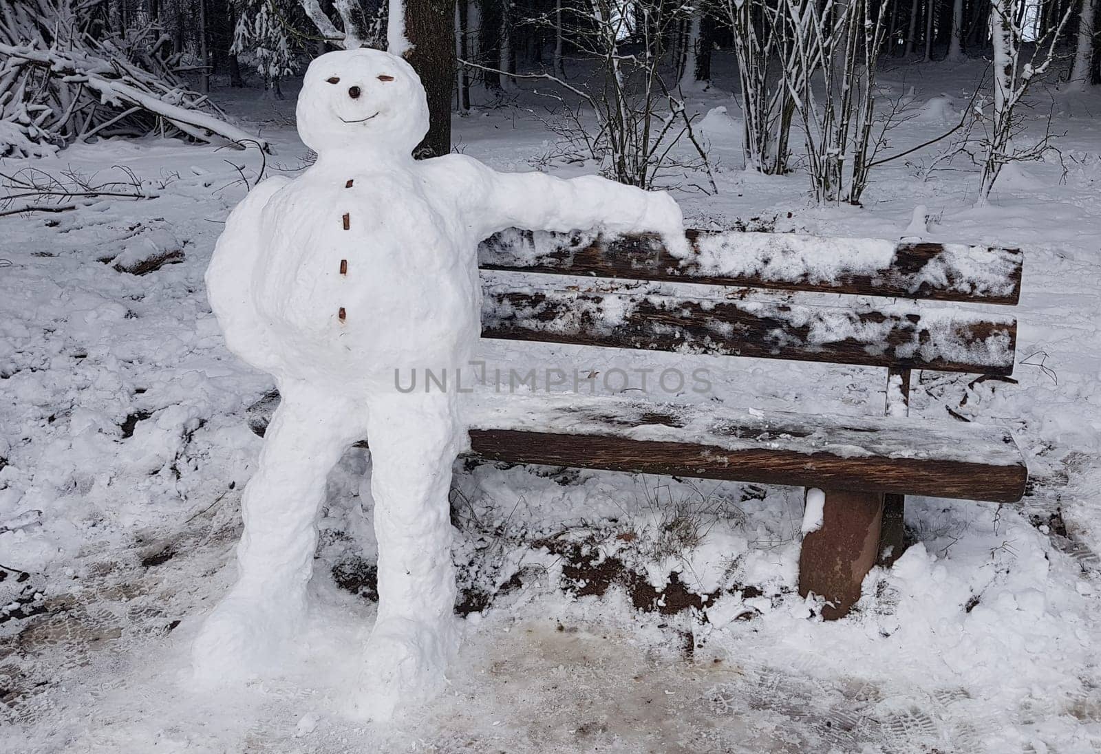 Snowman resting on a bench. Snowman resting on a bench.