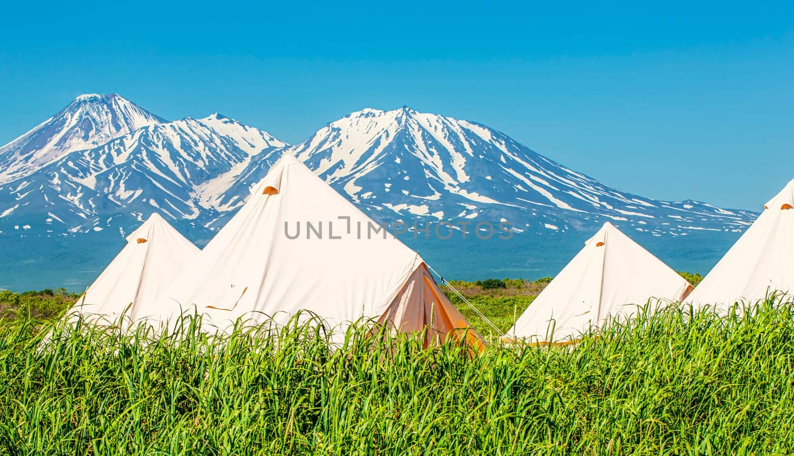 The Glamping house and volcano, rural landscape, tent houses in Kamchatka peninsula. Selective focus.