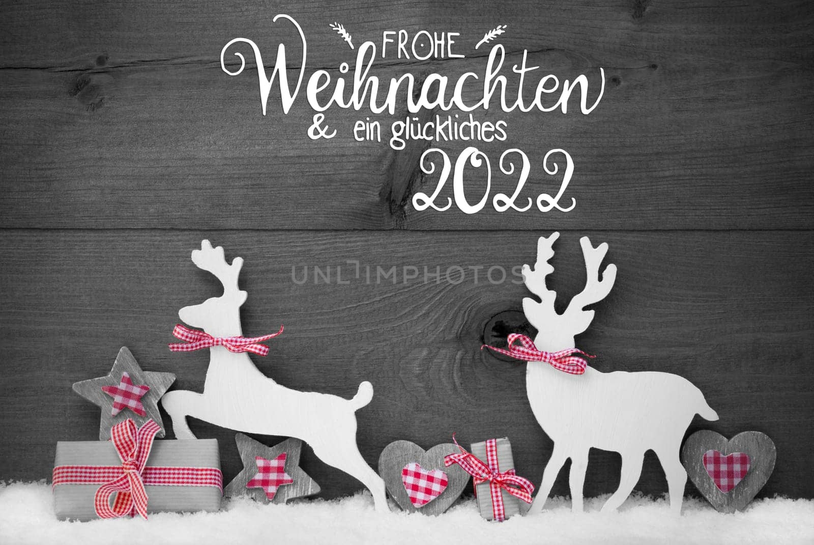 German Calligraphy Frohe Weihnachten Und Ein Glueckliches 2022 Mean Merry Christmas And Happy 2022. Wooden Christmas Ornament Like Present, Heart, And Wooden Deer. Gray Wooden Background With Snow