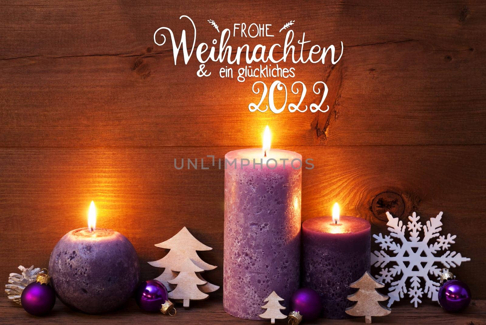 German Calligraphy Frohe Weihnachten Und Ein Glueckliches 2022 Mean Merry Christmas And Happy 2022. Purple Romantic Candle Light With Christmas Decoration. Brown Wooden Background