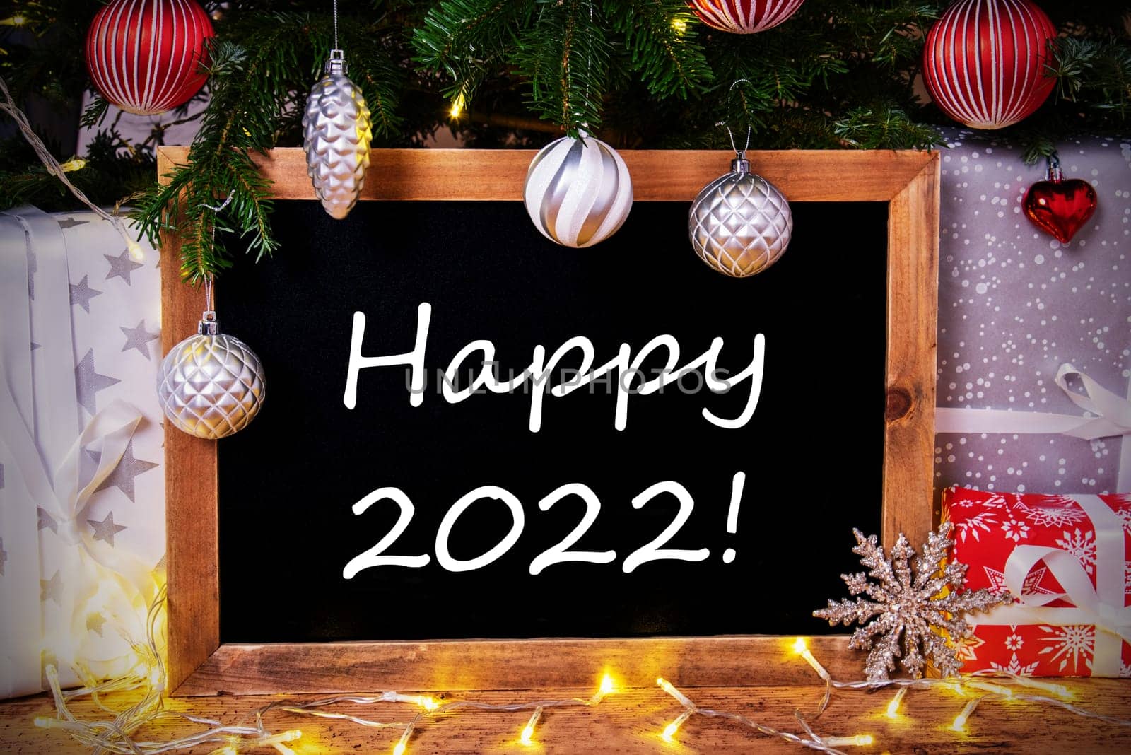 Blackboard With English Text Happy 2022. Christmas Tree With Ball, Gifts And Fairy Lights