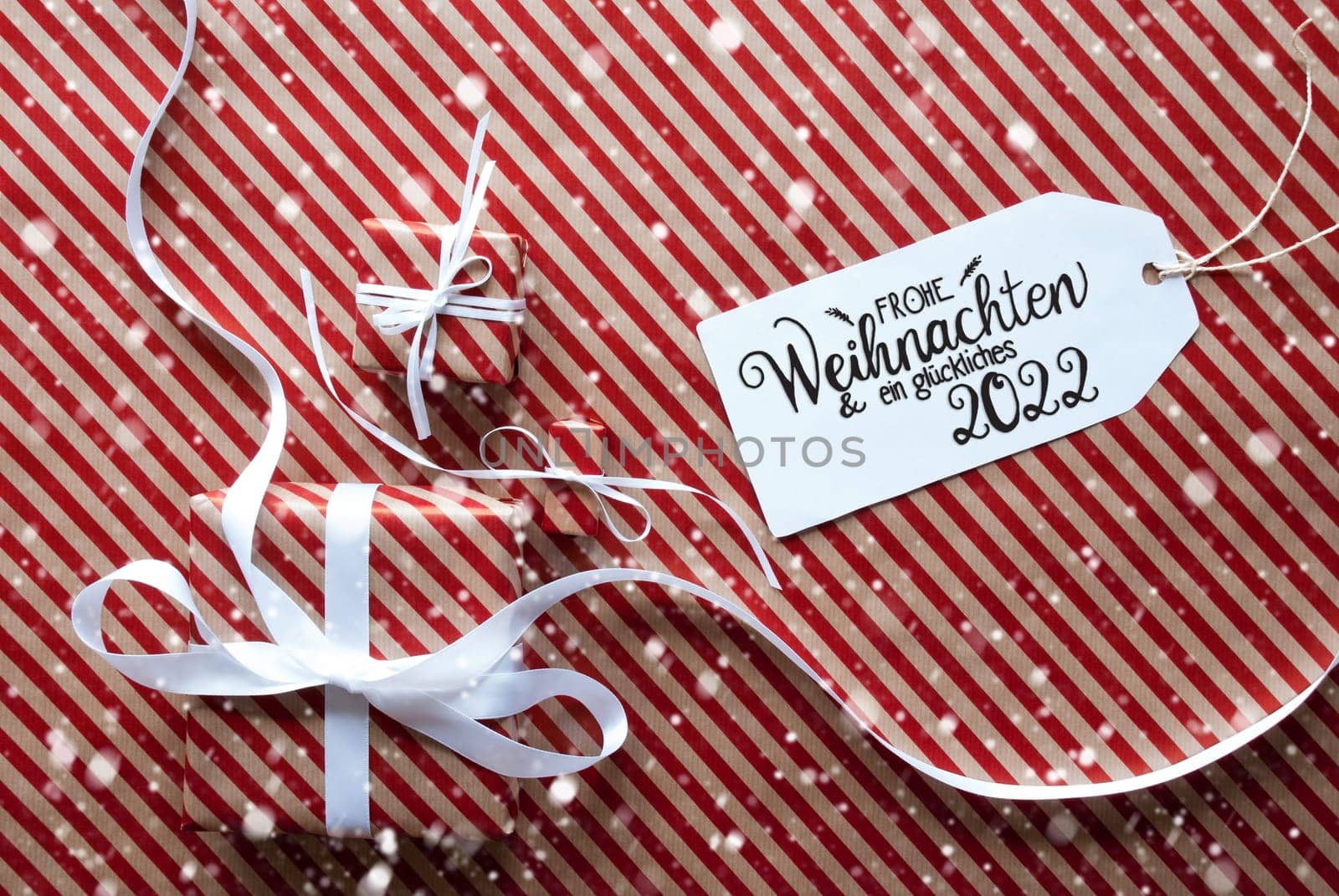 Label With German Text Frohe Weihnachten Und Ein Glueckliches 2022 Means Merry Christmas And Happy 2022. Gifts And Presents On Red And White Wrapping Paper With Snowflakes