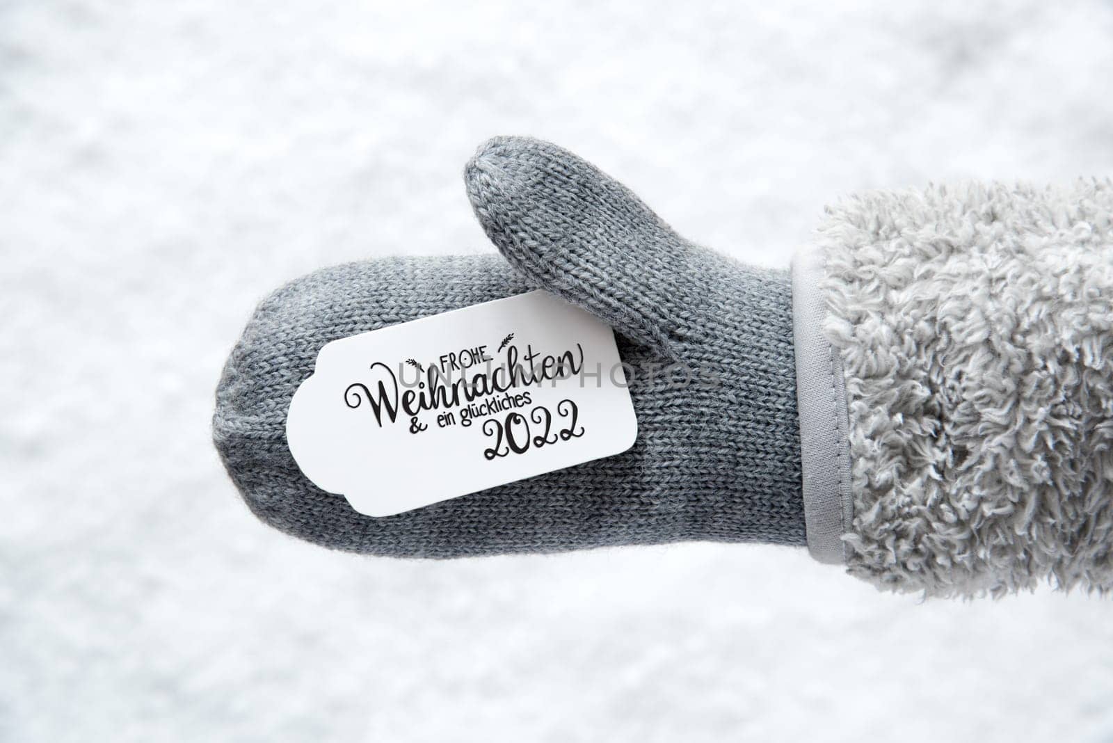 Label With German Calligraphy Frohe Weihnachten Und Ein Glueckliches 2022 Means Merry Christmas And A Happy 2022. Gray Glove With Snow Background