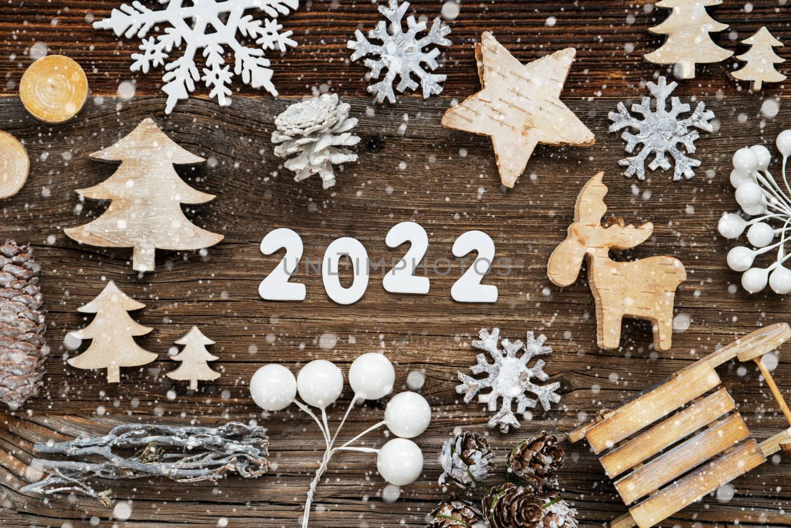 White Letters Building The Word 2020. Wooden Christmas Decoration Like Tree, Sled And Star. Brown Wooden Background With Snowflakes