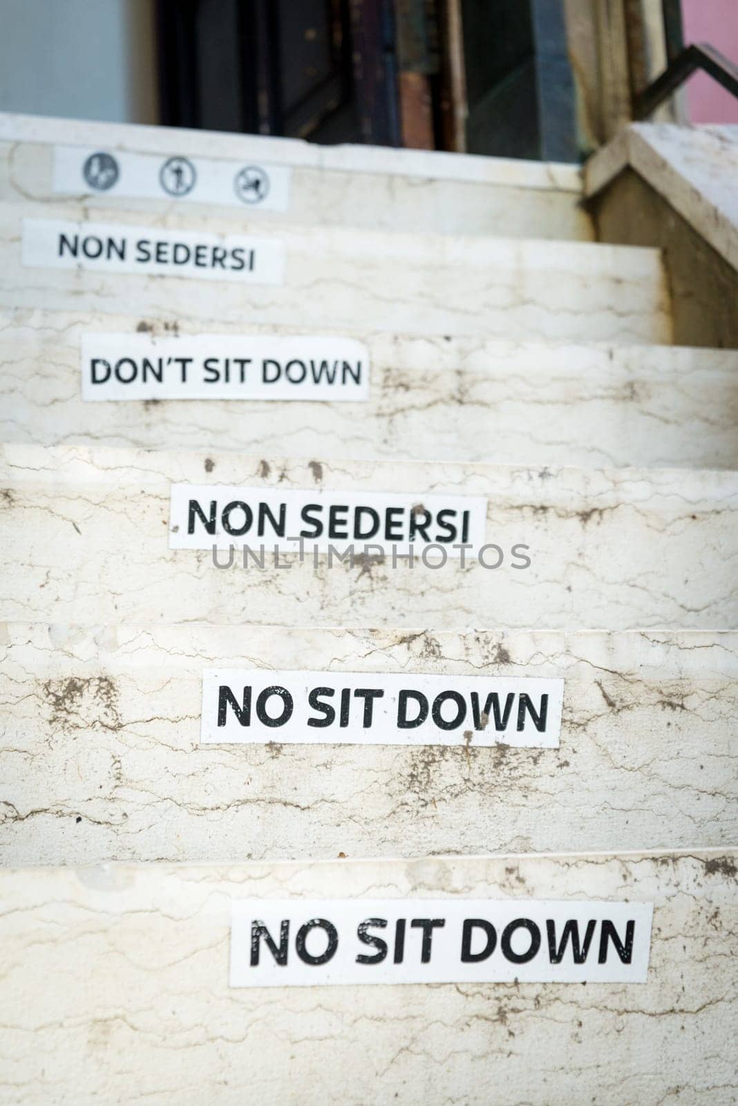 Old do not sit here sign on business entrance