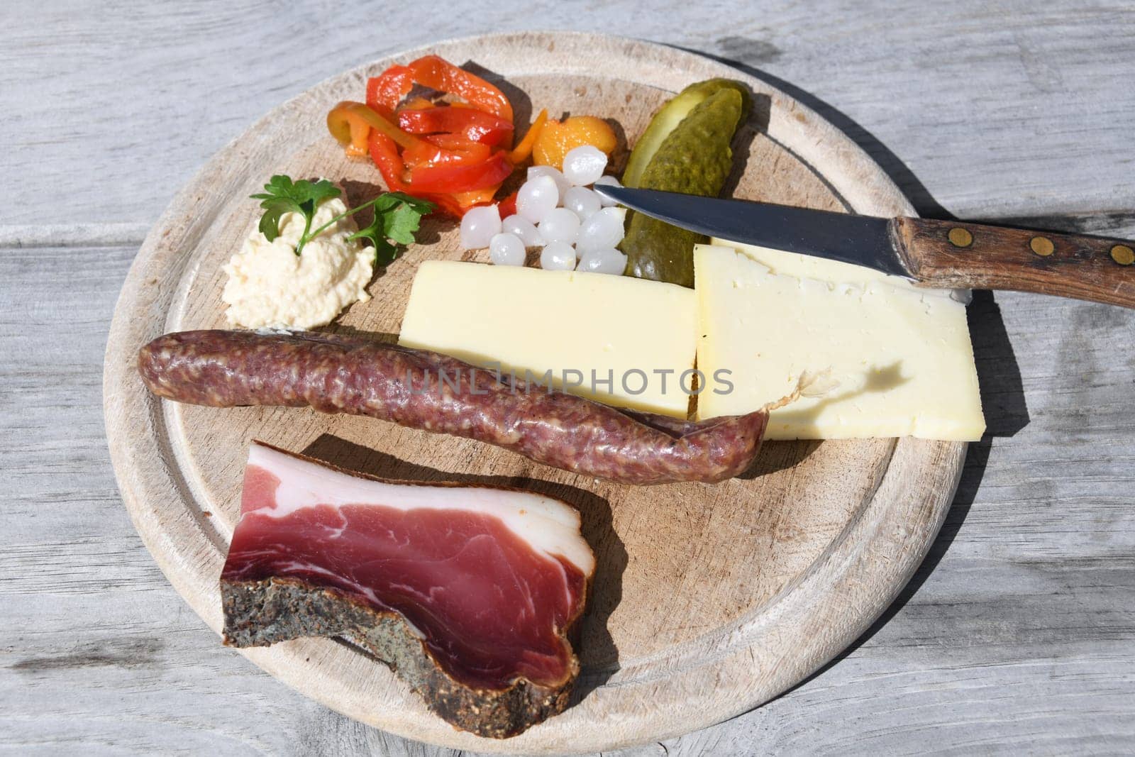 When hiking in the European Alps,people like to eat a snack plate to strengthen themselves in the huts. Salami,cheese,South Tyrolean ham and vegetables are served on the wooden plate.