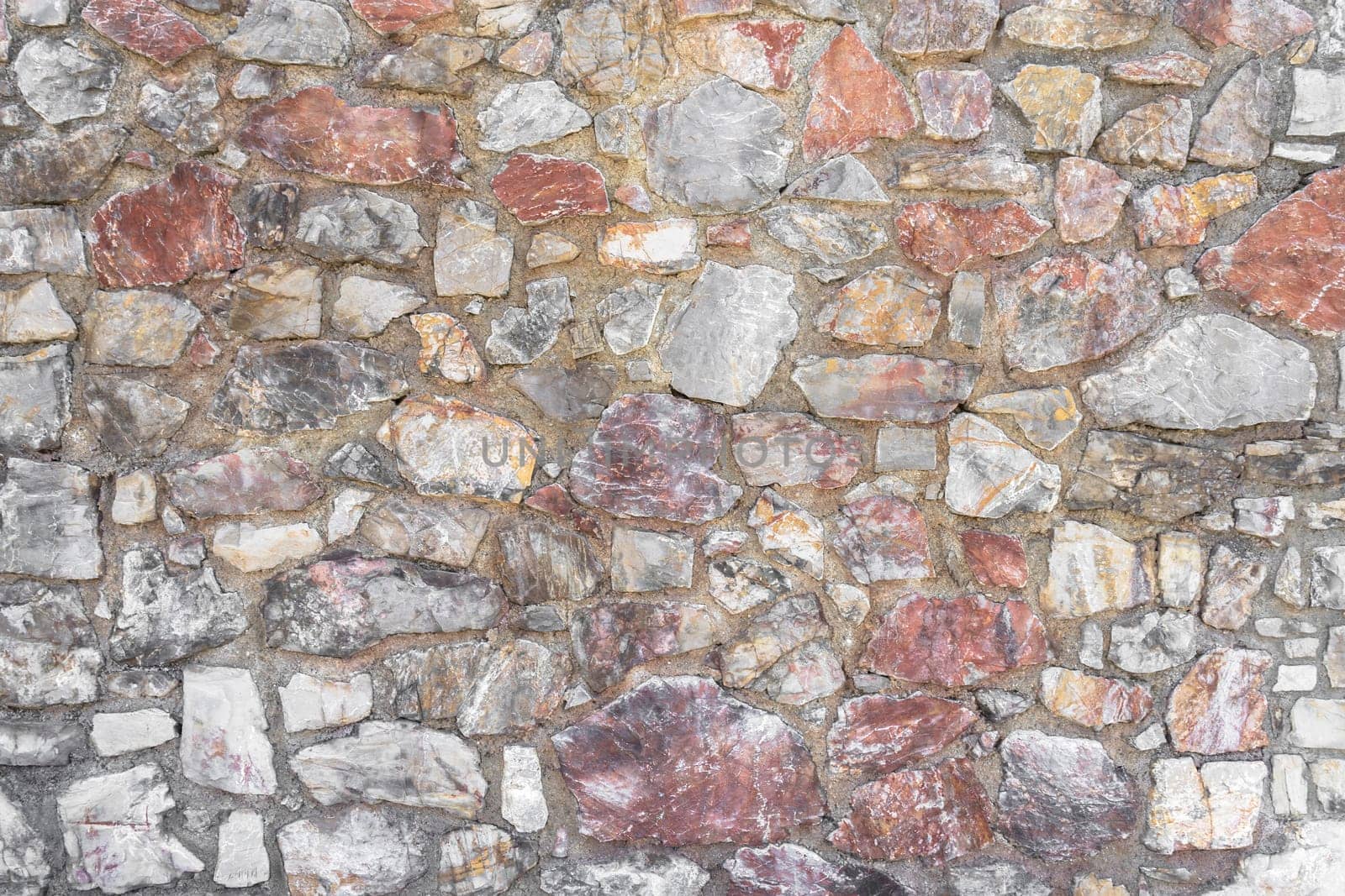 Irregular stone wall. Background wall made of stones held together with cement.