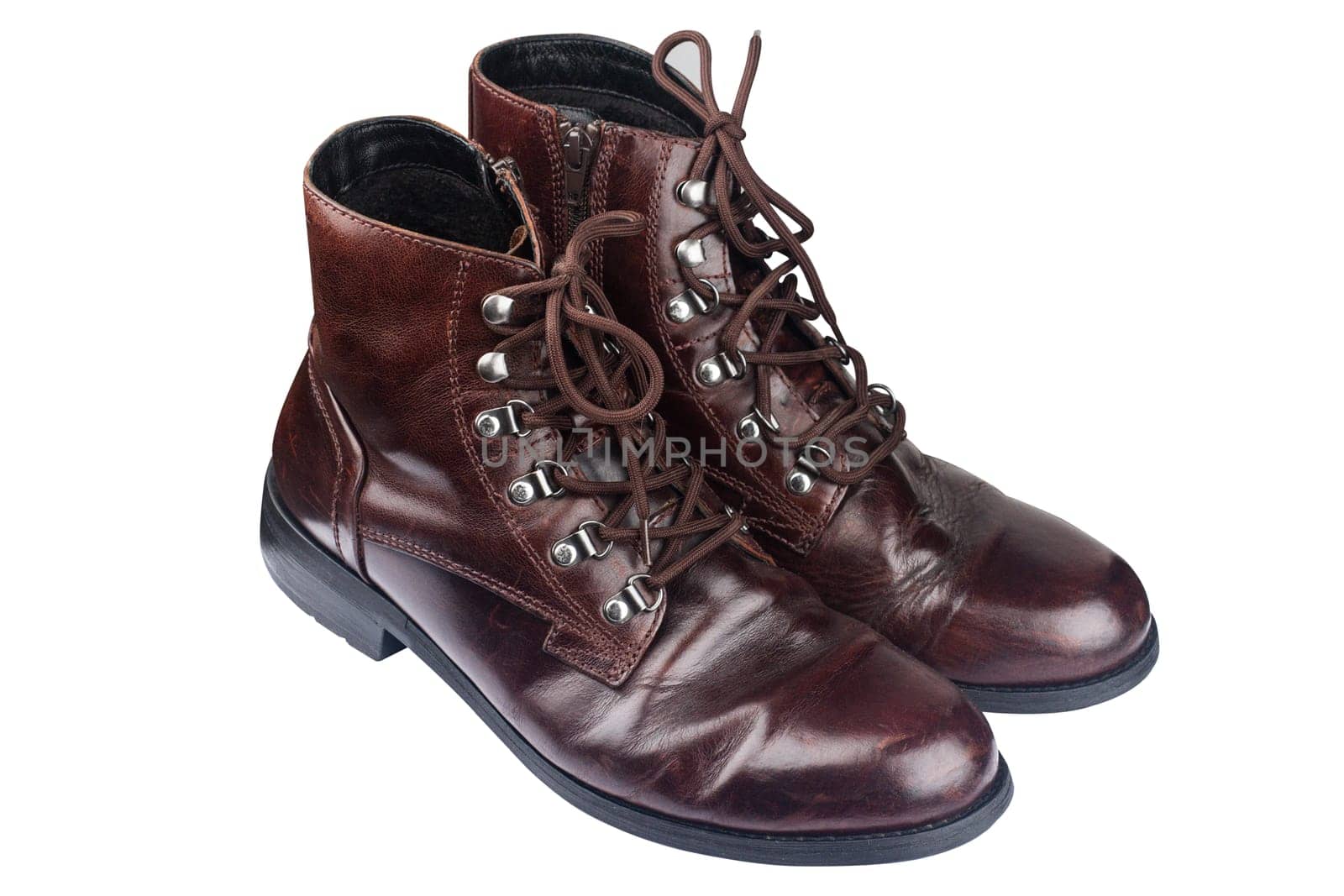 side view closeup of a pair of polished vintage brown leather boots isolated on white background