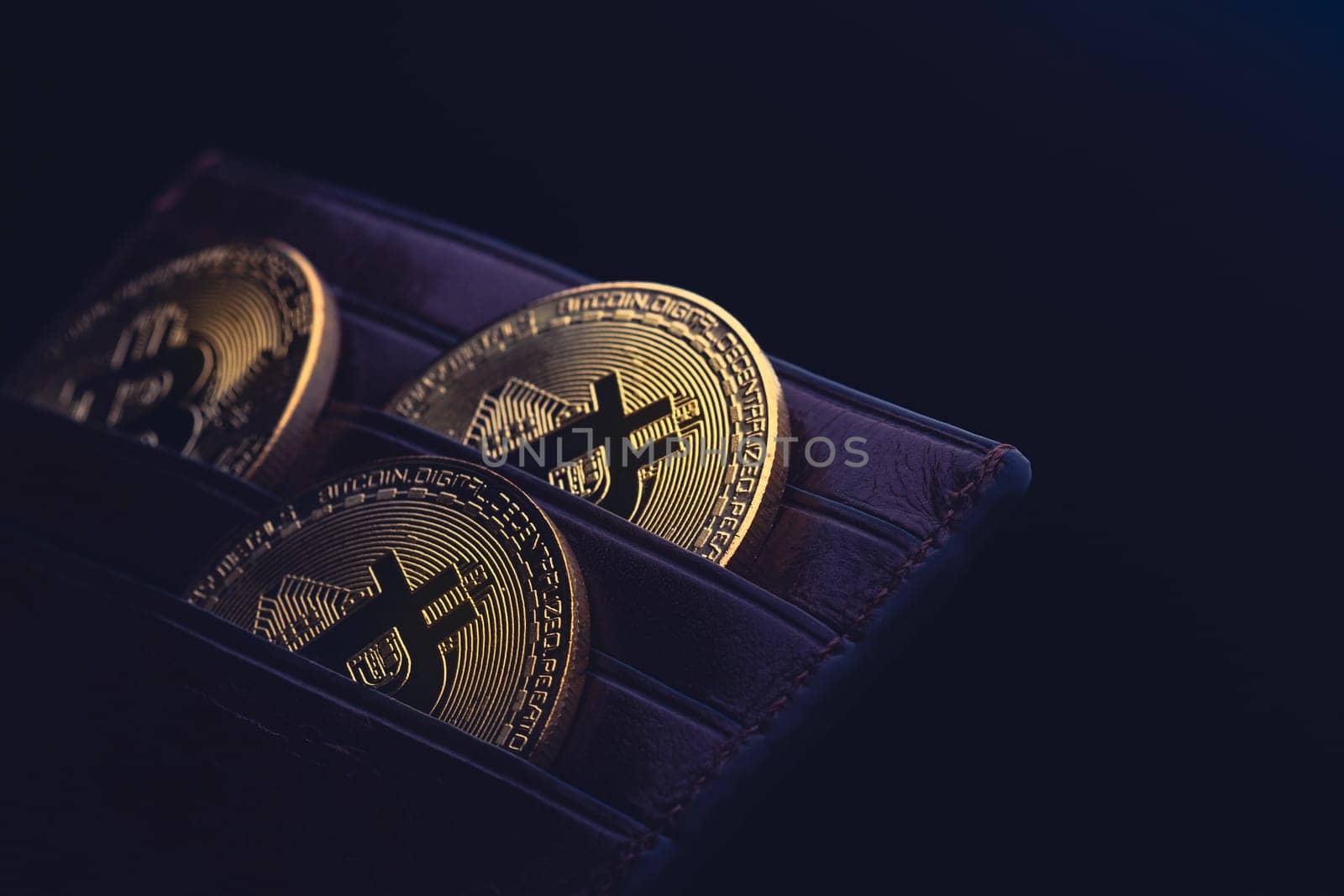 side view closeup concept of bitcoin cryptocurrency golden coins in leather black money wallet