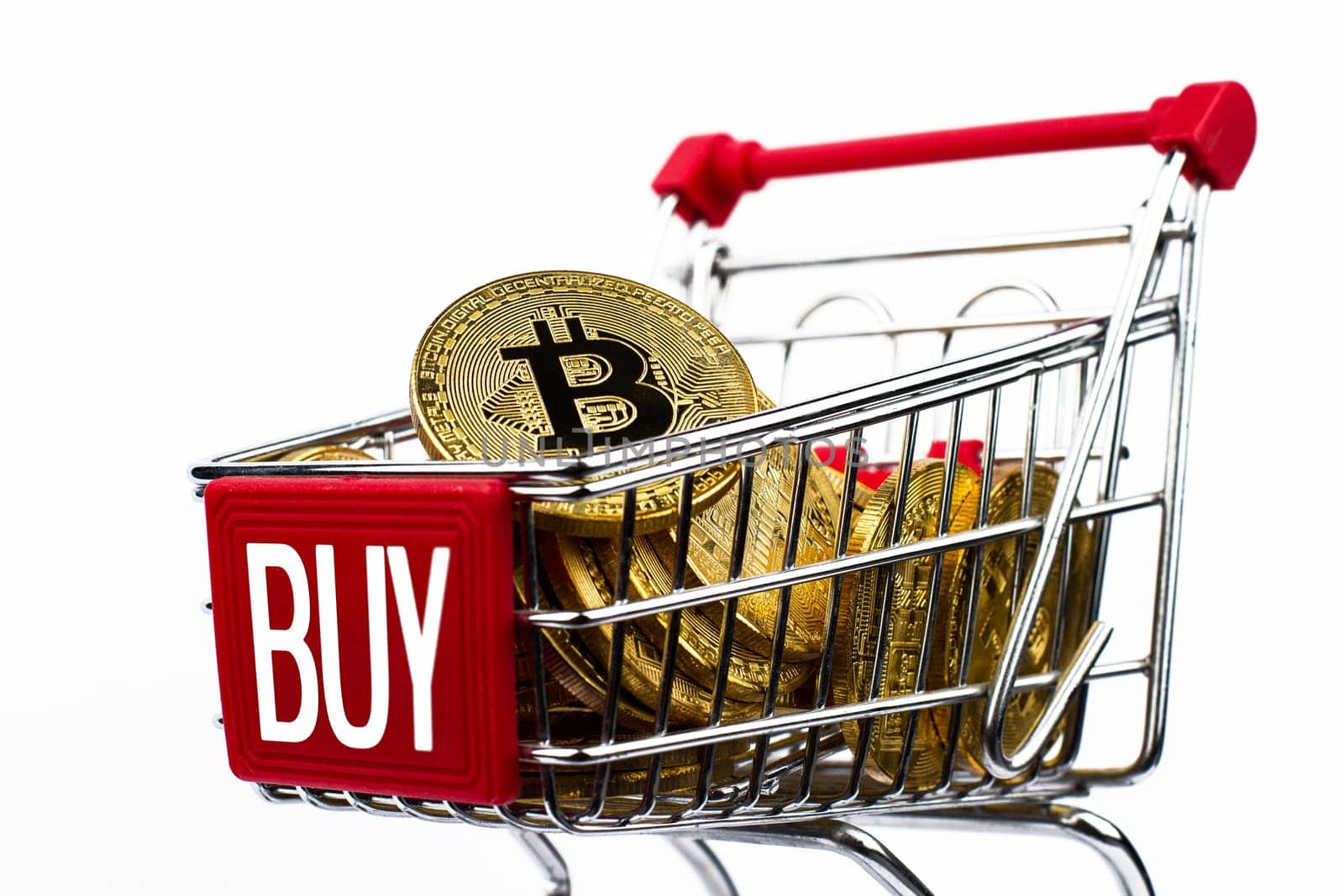 side view closeup cryptocurrency concept of market shopping cart full of bitcoin golden crypto coins with word buy written on front isolated on white background