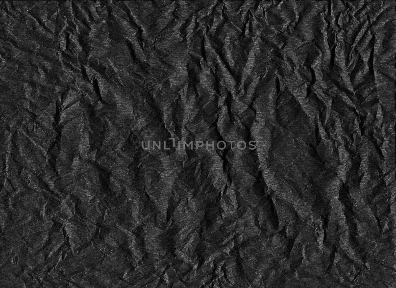 horizontal front view of crumpled dark black paper texture with heavy wrinkles background
