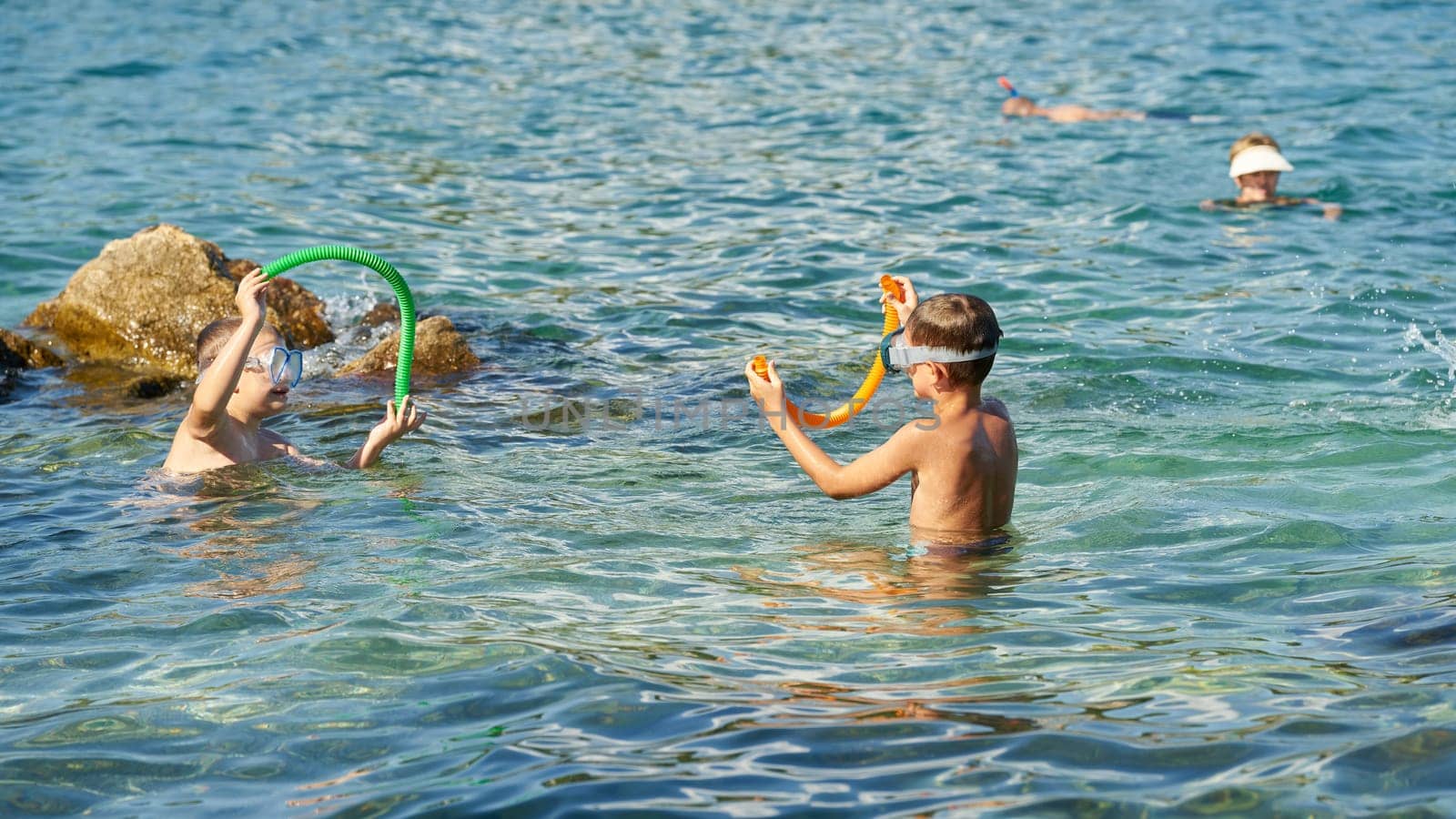 bathing children with diving goggles and snorkel in Adriatic Sea near town Krk in Croatia