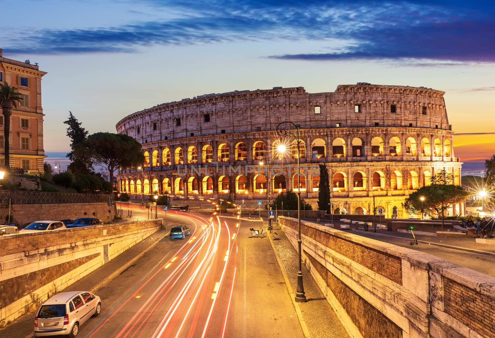 Beautiful view on Colosseum and a road nearby at sunset, Rome, Italy.