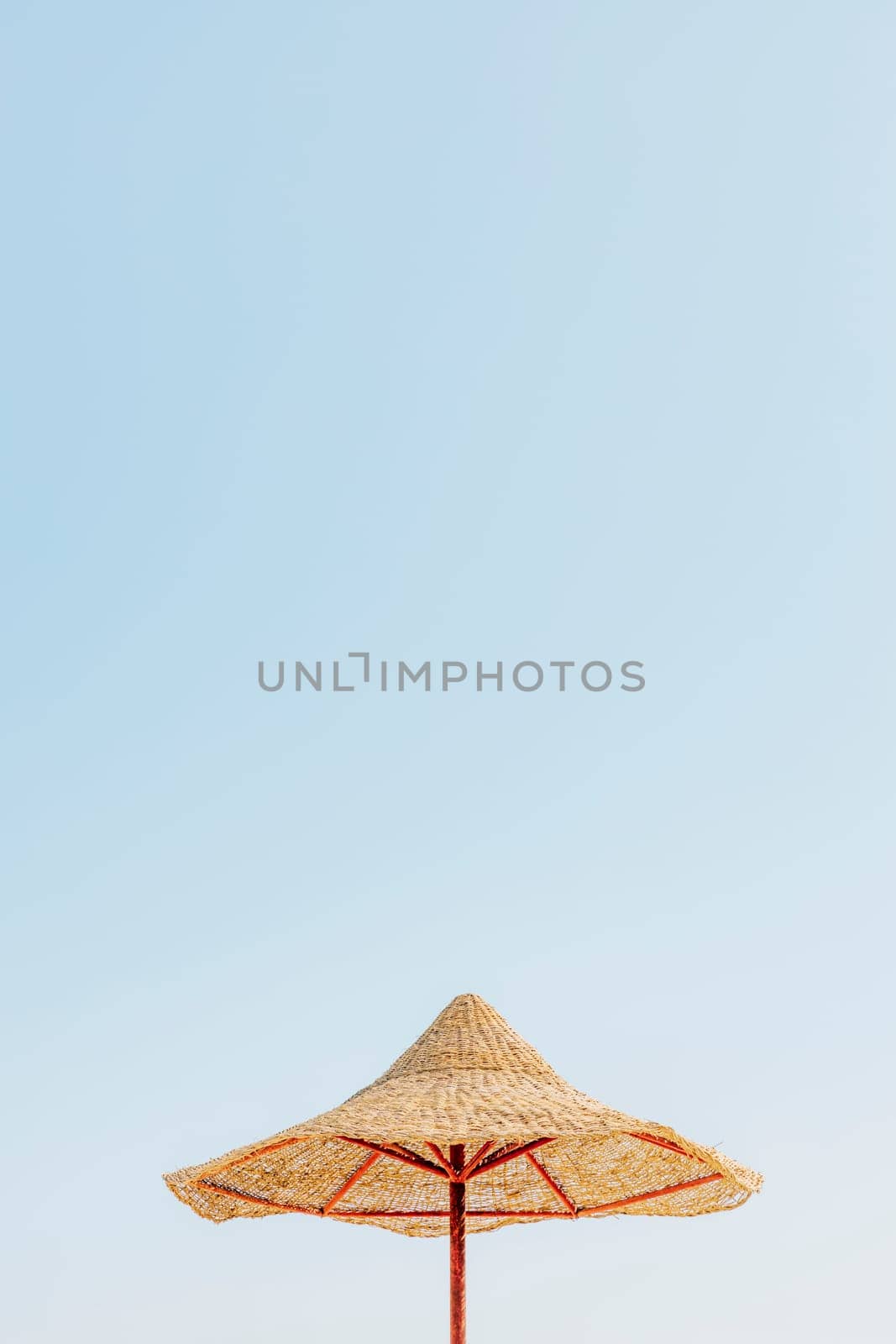 Looking up at wooden straw umbrella or thatched hut from below against beautiful cloudy blue sky view on tropical Egypt beach. Summer or winter holiday concept. Egyptian resort. High quality photo