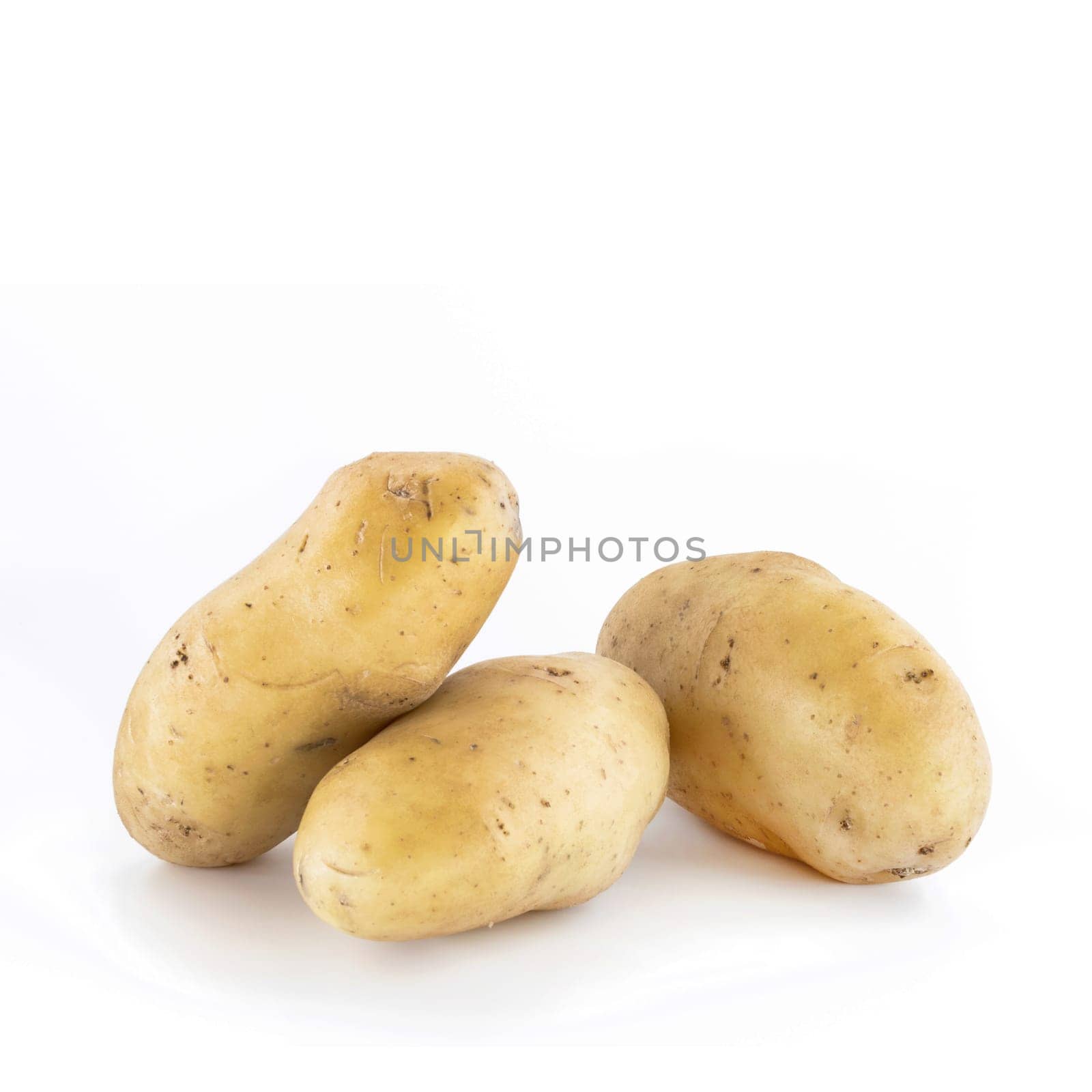 Three potatoes isolated on white background. Raw food. Peel details.