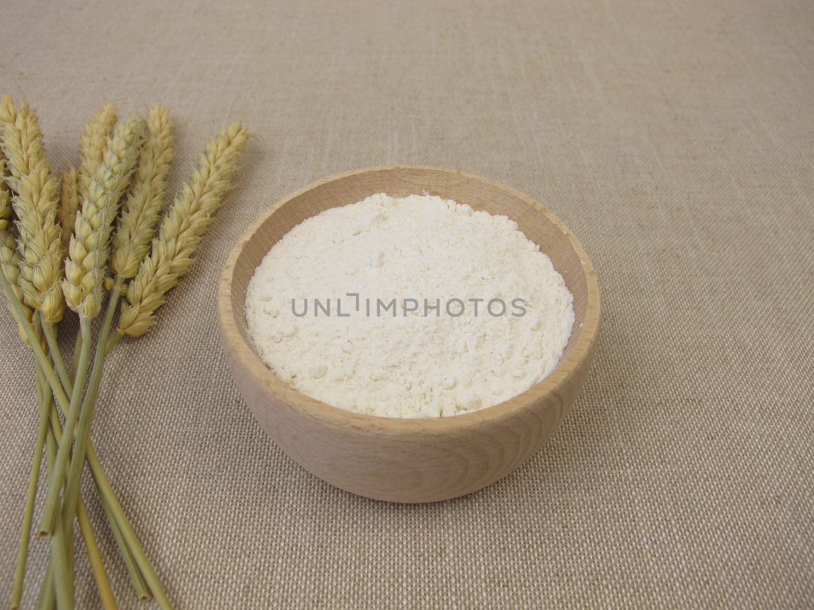 Fine wheat flour in a wooden bowl for the production of baked goods and pasta