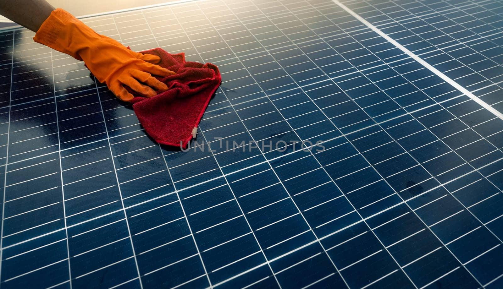Man cleaning solar panel on roof. Solar panel or photovoltaic module maintenance. Sustainable resource and renewable energy for go green concept. Solar power for green energy. Technology for future.