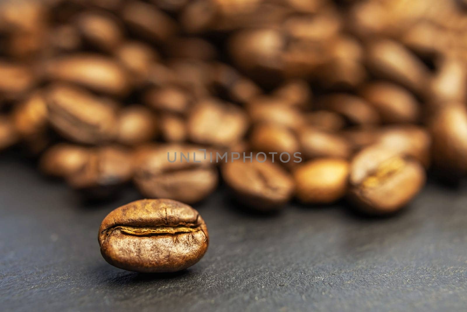 Roasted coffee beans background on a stone table. Horizontally.