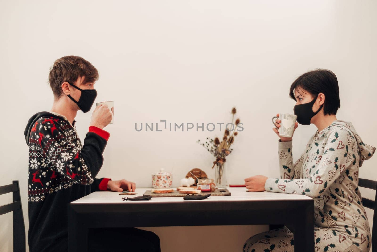 Girl and Guy Have Breakfast at Home in Masks.