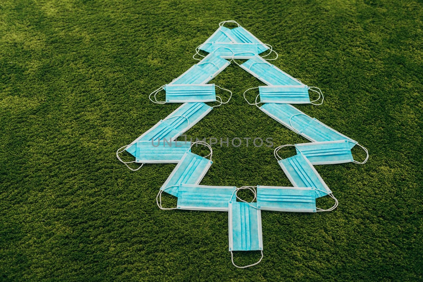 Christmas Tree Made of Medical Masks on a Green Background