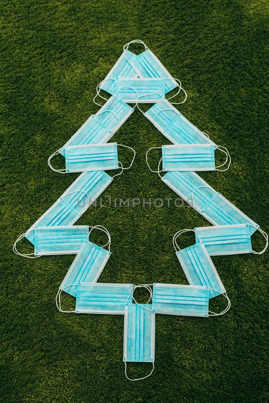 Christmas Tree Made of Medical Masks on a Green Background