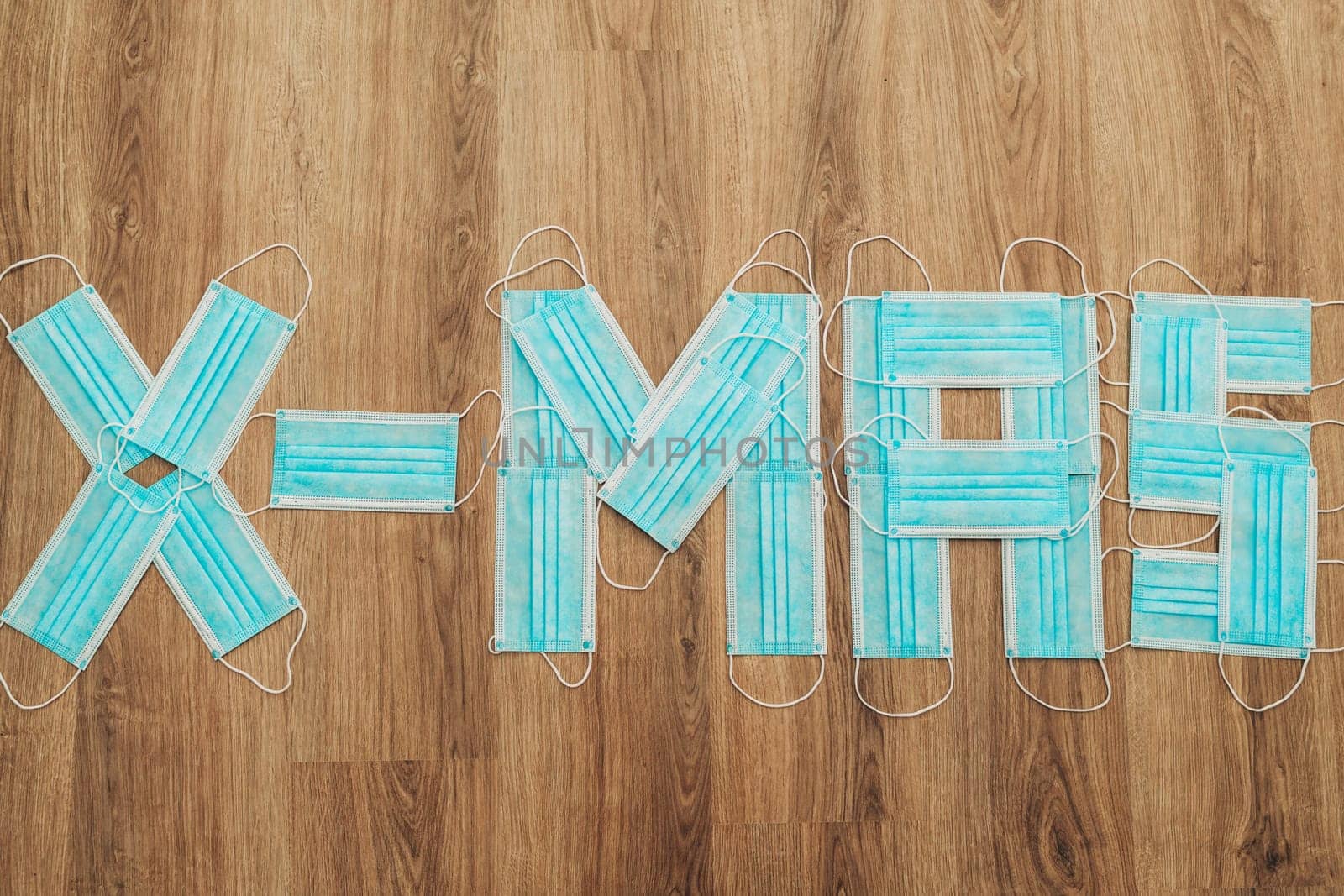 Capital Letters Happy Composed of Medical Masks on a Brown Background with Copy Space