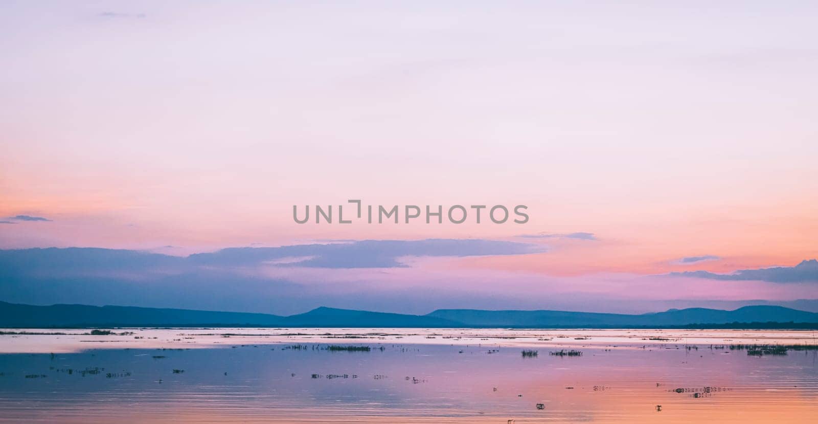 Panorama lake and mountain landscape at sunset with pink sky