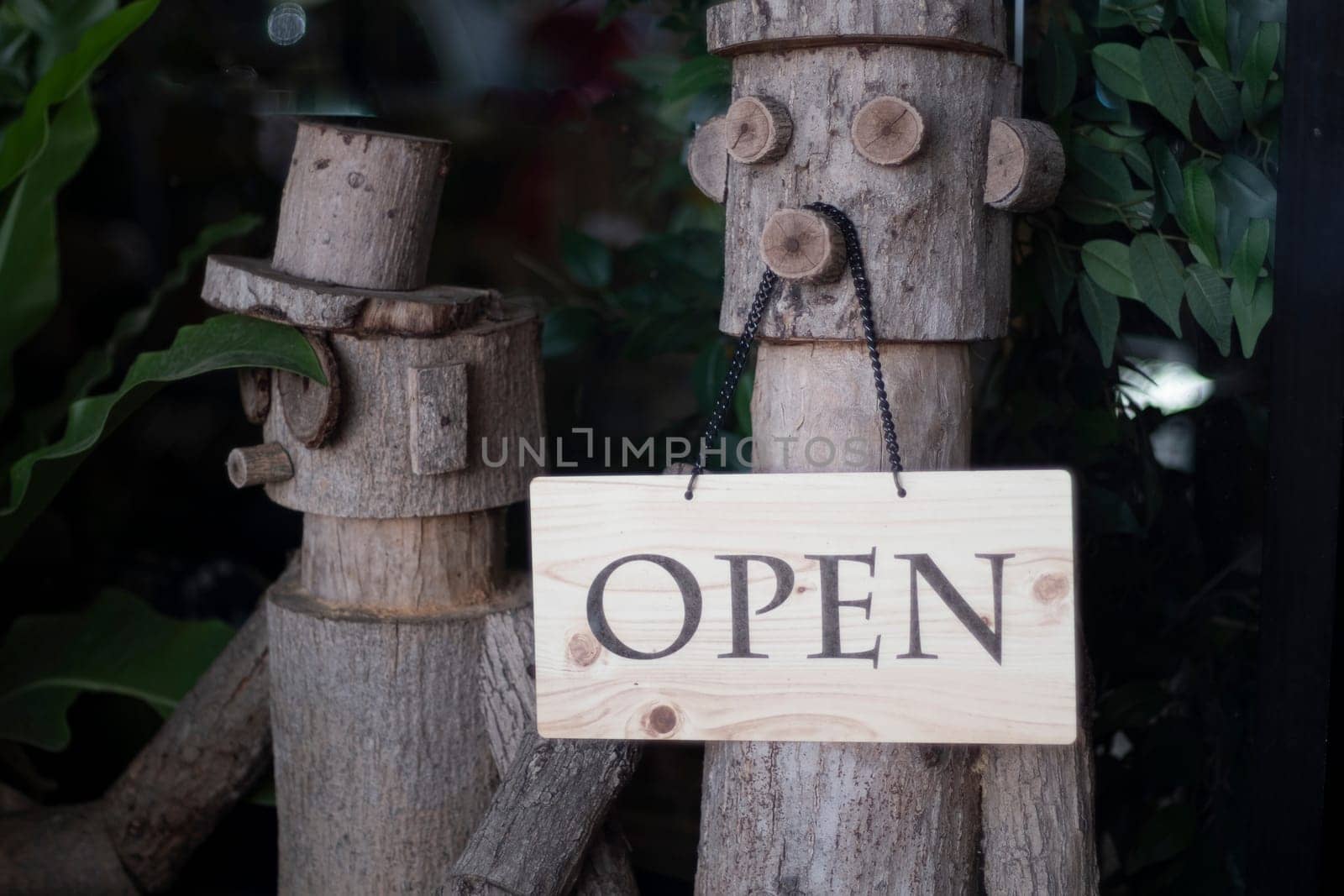 Open Sign Hanging on wooden doll in front of entrance door for decoration cafe restaurant.