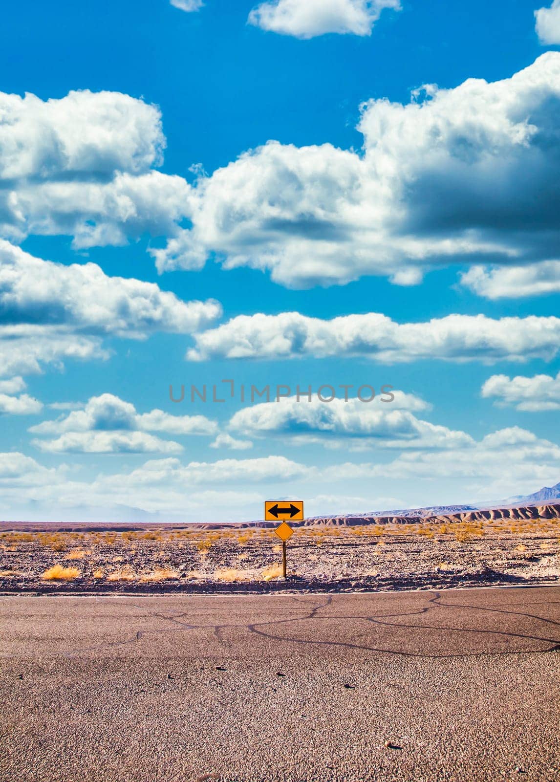 Directional sign in the desert with scenic blue sky and wide horizon. Concept for trip, freedom, holiday and transportation.