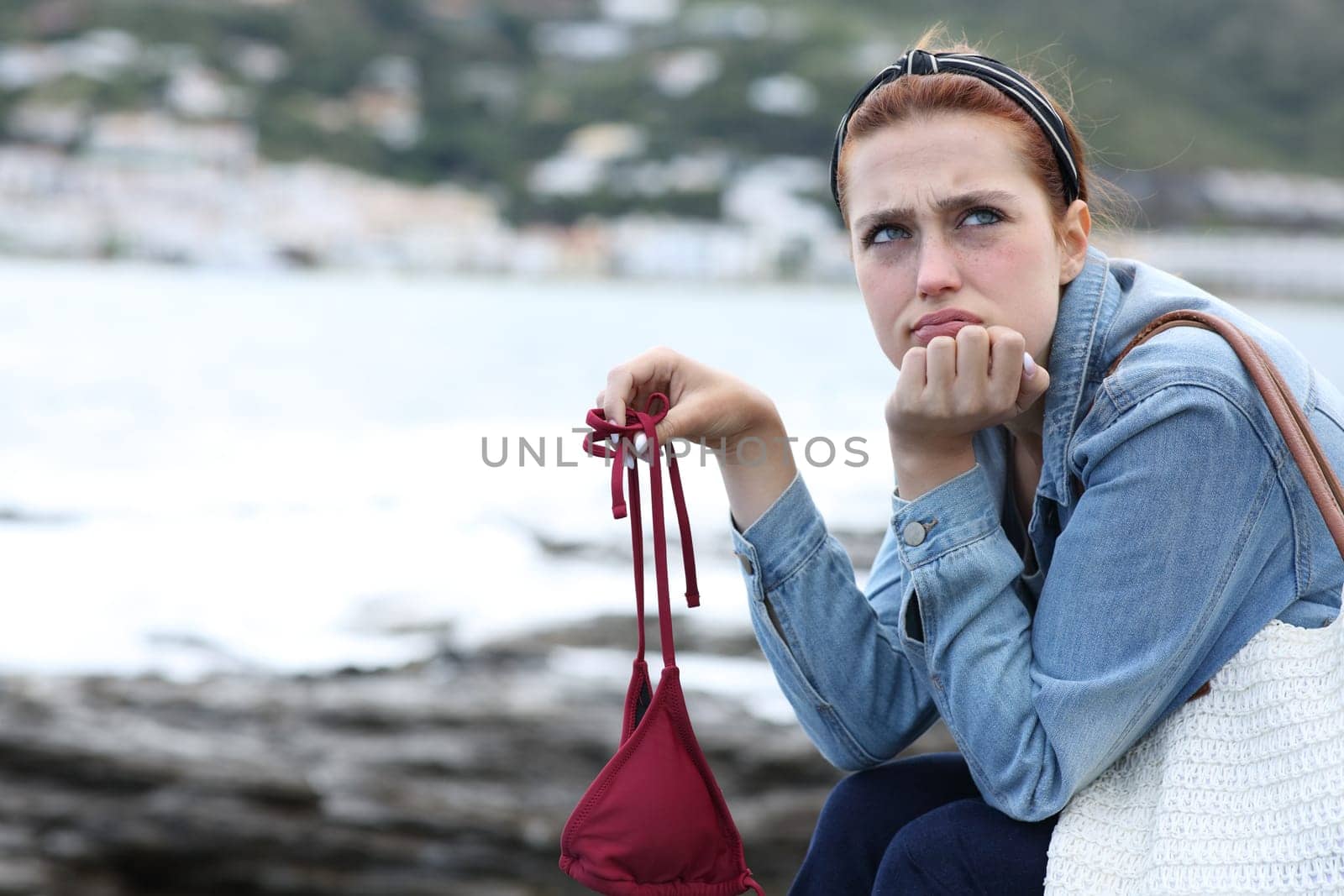 Frustrated tourist on the beach a bad weather day