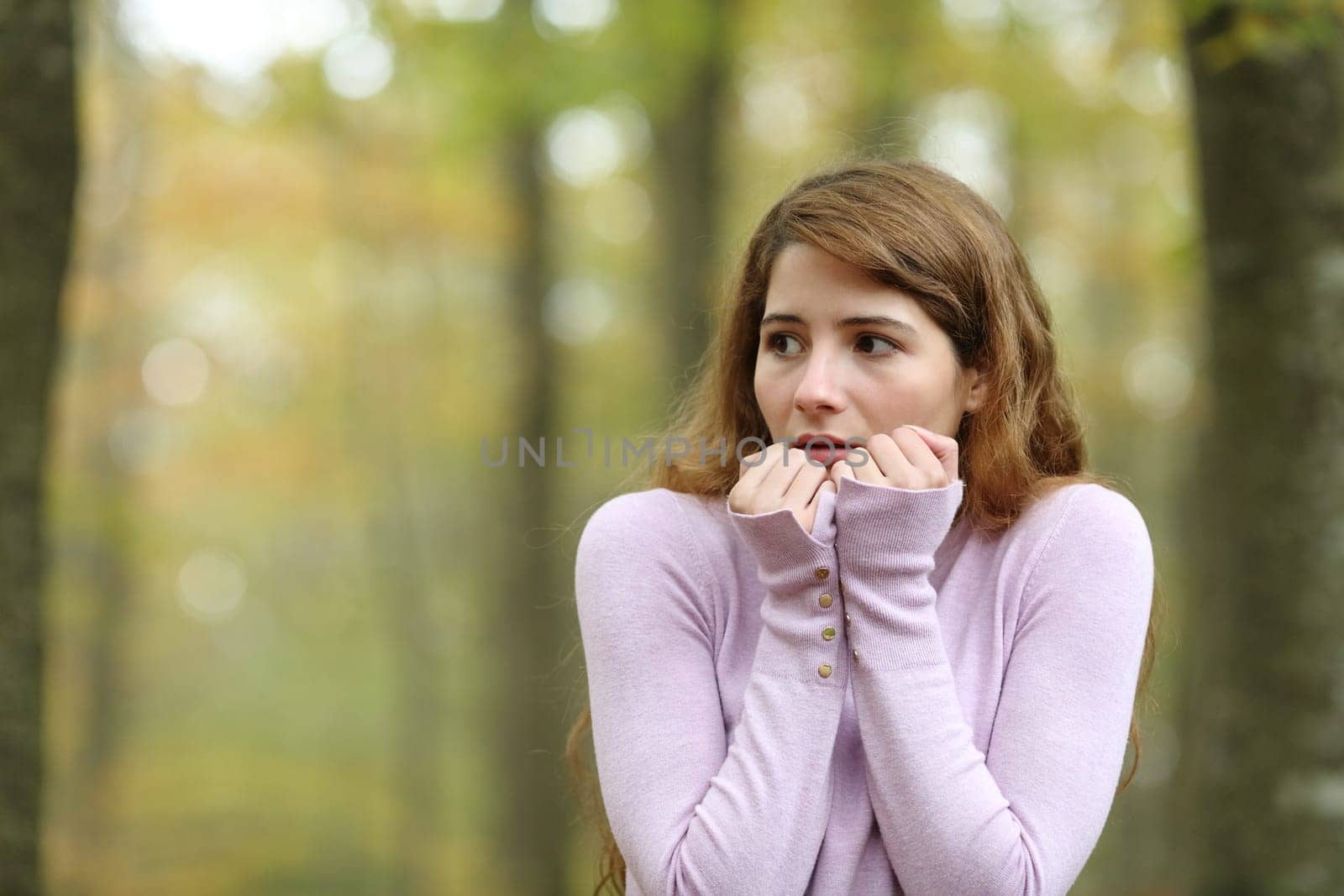 Scared woman looking at side alone in a park