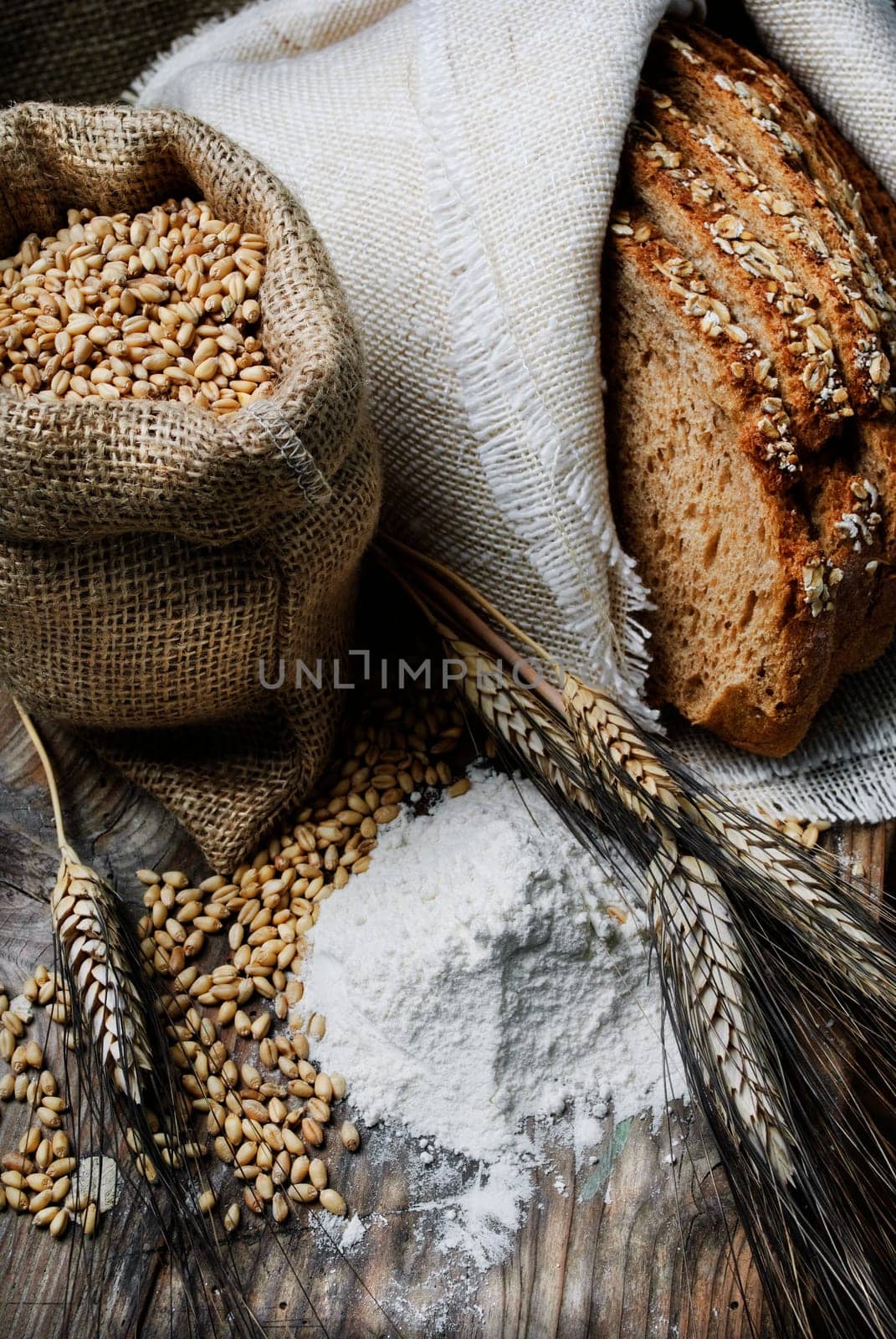 Bread and wheat ears on vintage wooden board