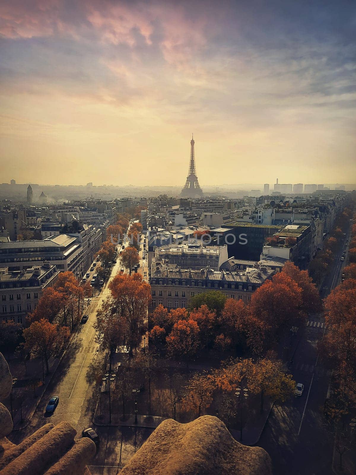 Aerial cityscape view from the top of triumphal arch to the Paris city, France. Travel concept vertical background. Autumn season sunset scene with Eiffel tower on the horizon