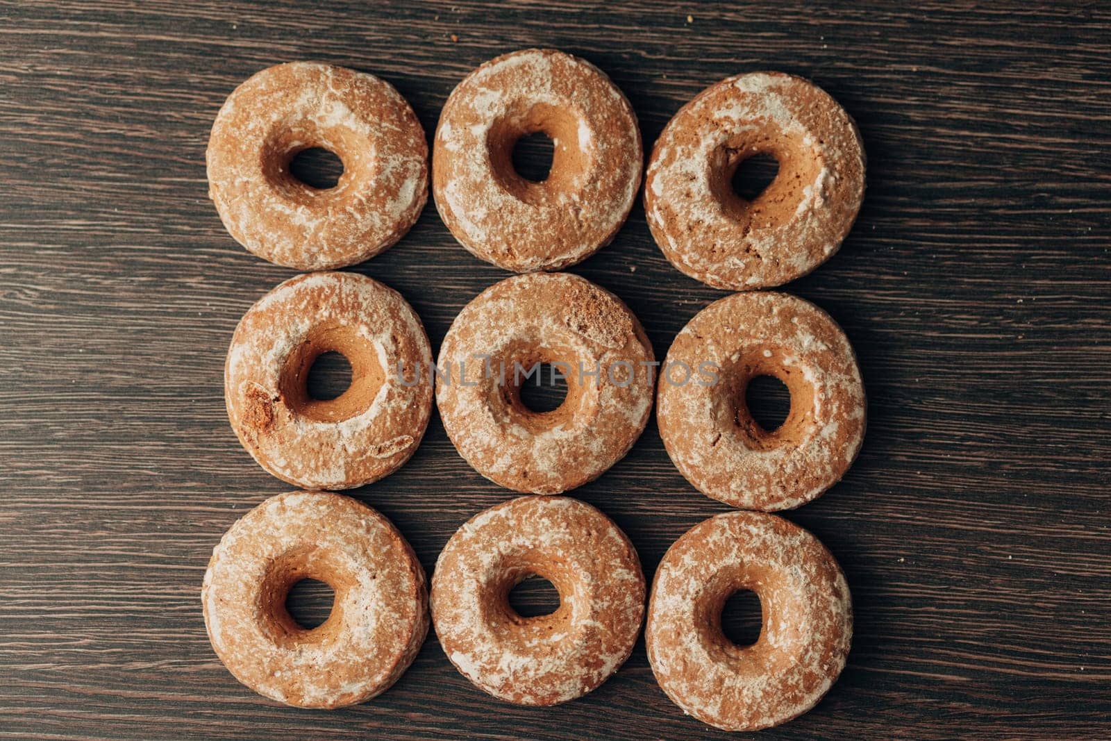 Beautiful Many Bagels and Gingerbreads Lie on a Brown Background