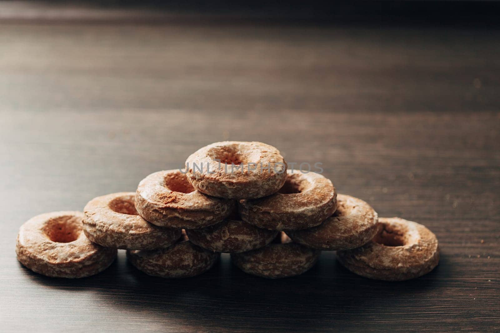 Beautiful Many Bagels and Gingerbreads Lie on a Brown Background
